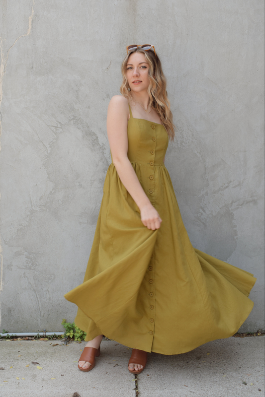 spaghetti strap midi dress with pleats at waistline fitted bodice buttons all down the front that are the same color as the dress, adjustable straps, has pockets, square neckline, smocked panel on back of bodice