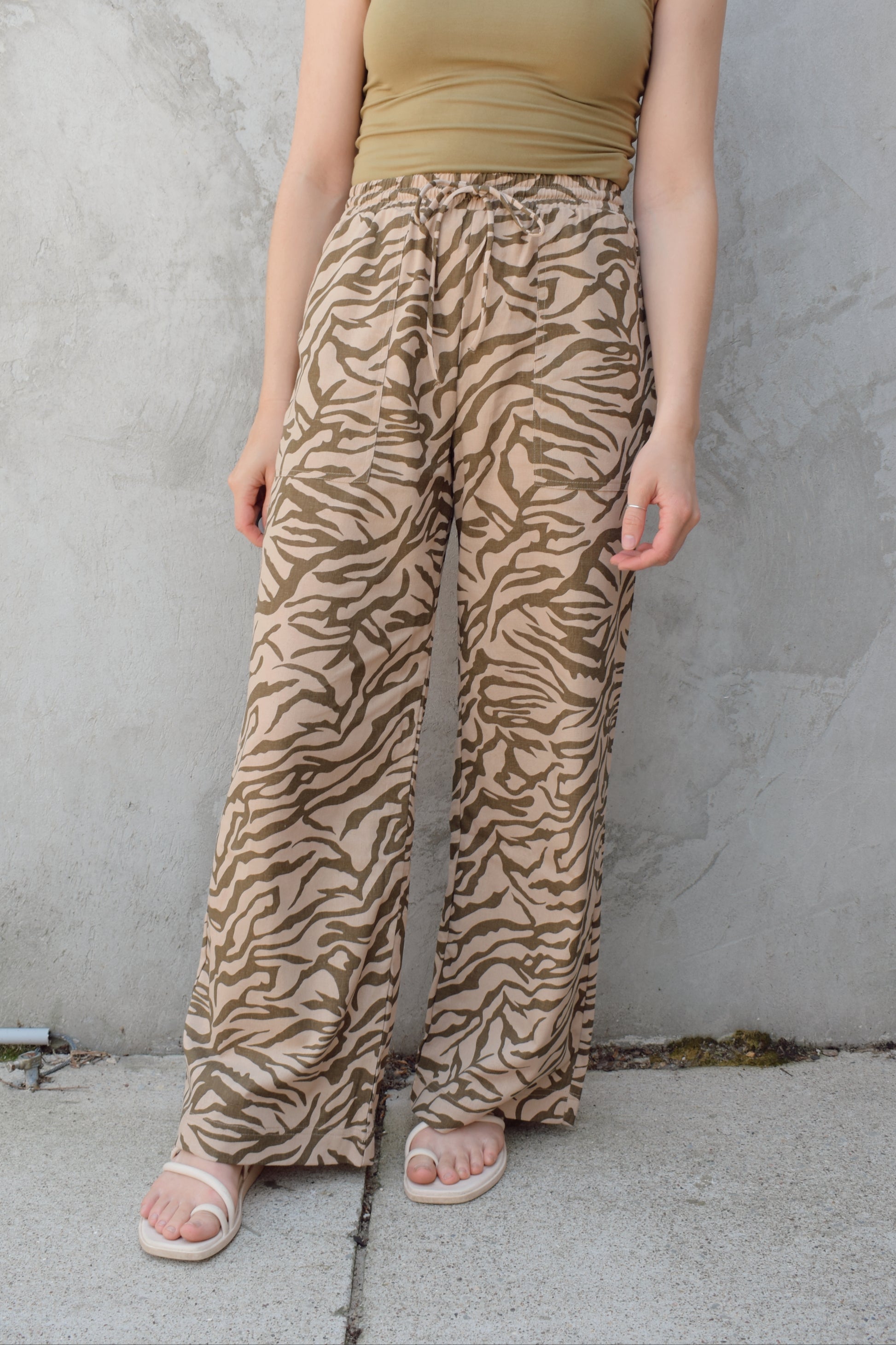 zebra print linen blend pants with relaxed wide leg fit, high rise with elastic waist and drawstring, front patch pockets and fake back pocket slits, full length