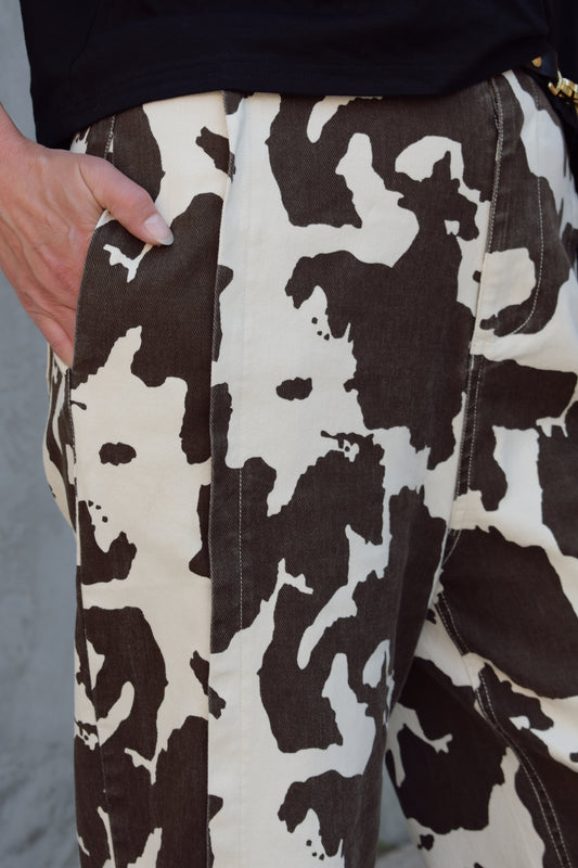 high rise cow print pants with zip and clasp enclosure, seam detailing, elastic on back of waistband, wide leg full length, has front pockets and back pockets