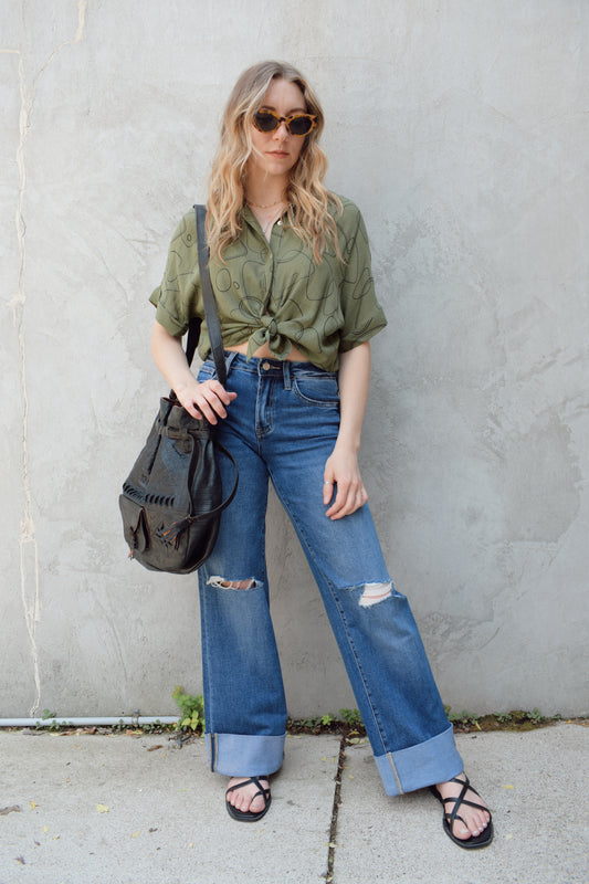 wide leg wide cuff at hem stretch denim jeans with holes in both knees, full length, dark wash, zip and button enclosure