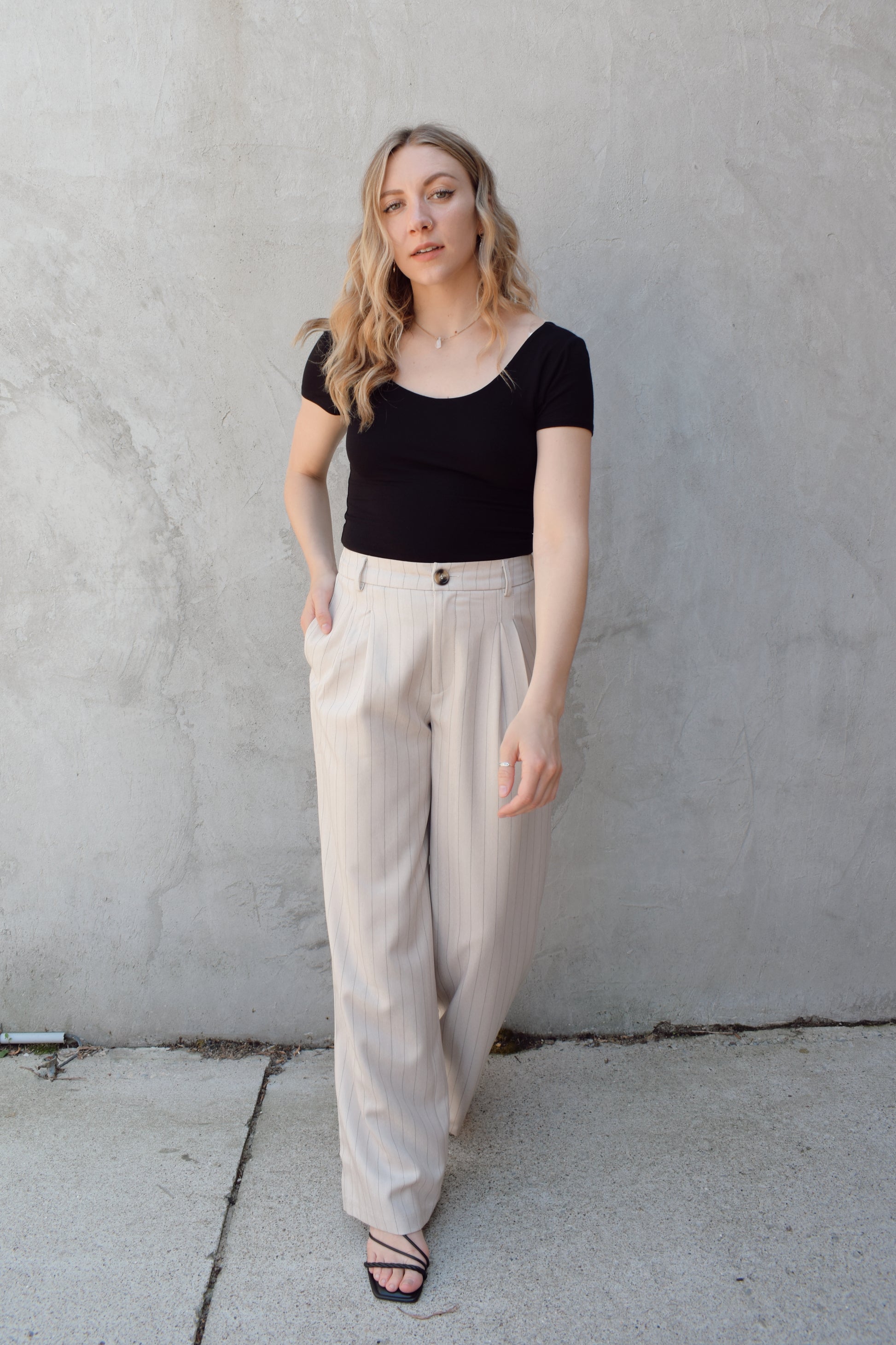 vertical pinstripe trousers with front pleats, pockets, zip and button enclosure, has beltloops, fake back pockets, elastic on back of waistband, full length