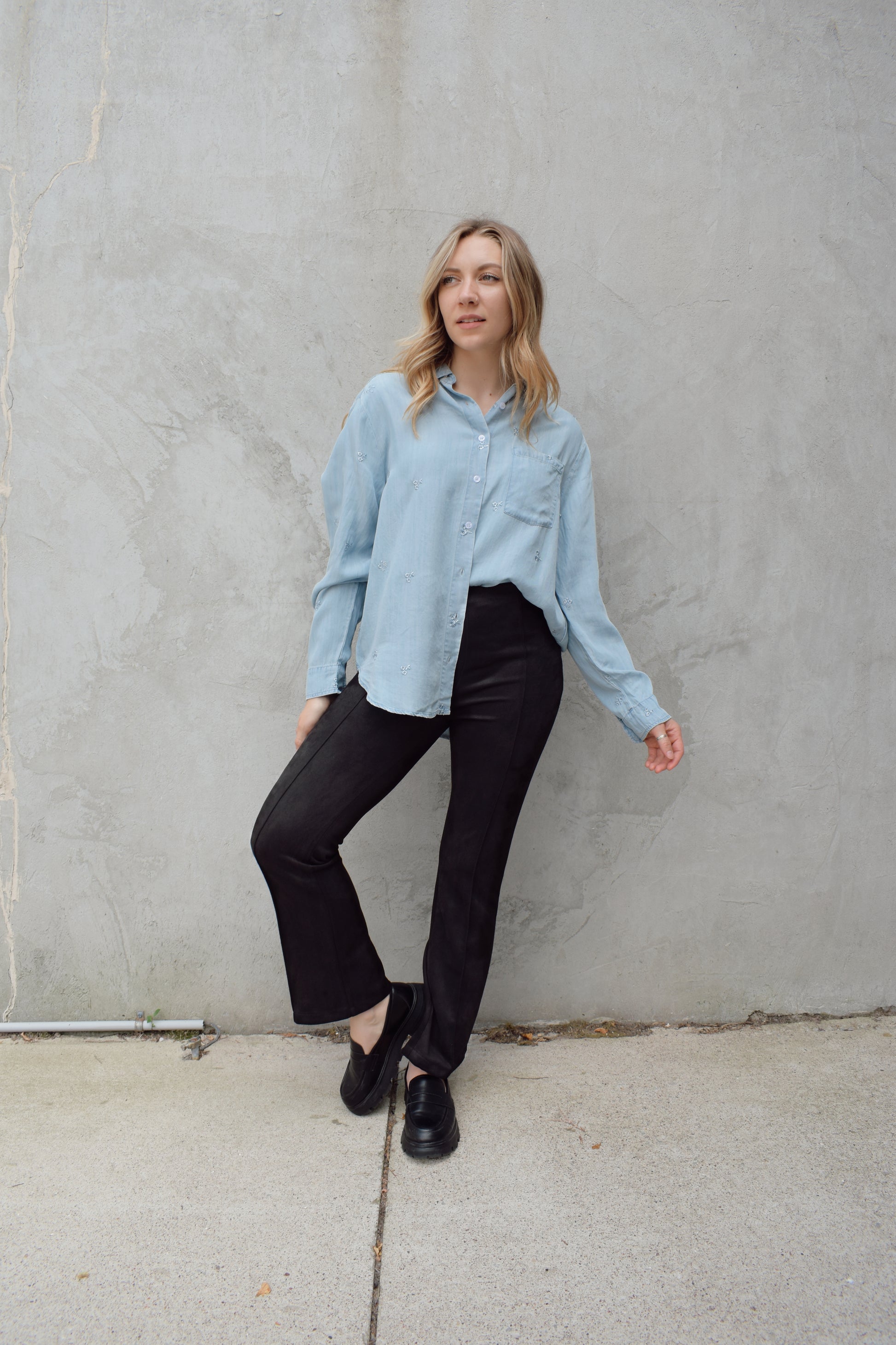 black faux suede pants with a slight cropped kick flare, raised seam detail along front of pant legs, zip side enclosure, high waisted, no pockets