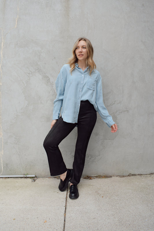 black faux suede pants with a slight cropped kick flare, raised seam detail along front of pant legs, zip side enclosure, high waisted, no pockets