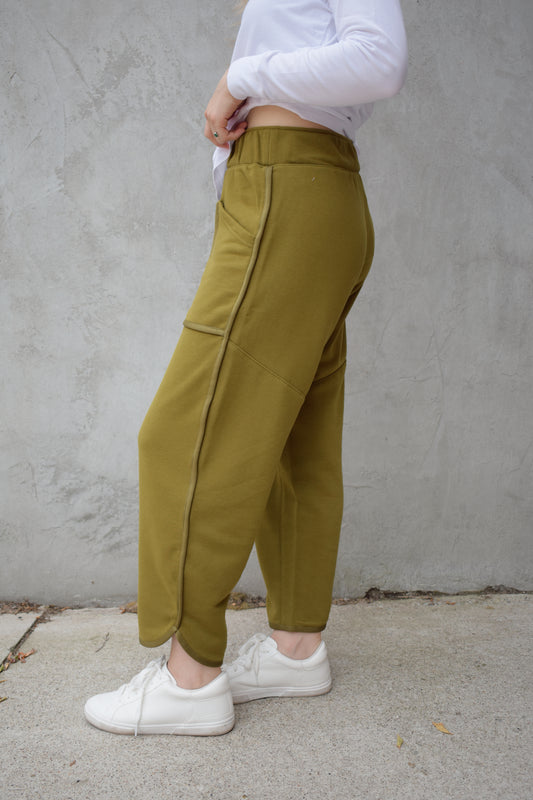 lounge pants with relaxed cropped fit, curved hem, oversized front bucket patch pockets, elastic waistband, seam detailing along sides, athleisure