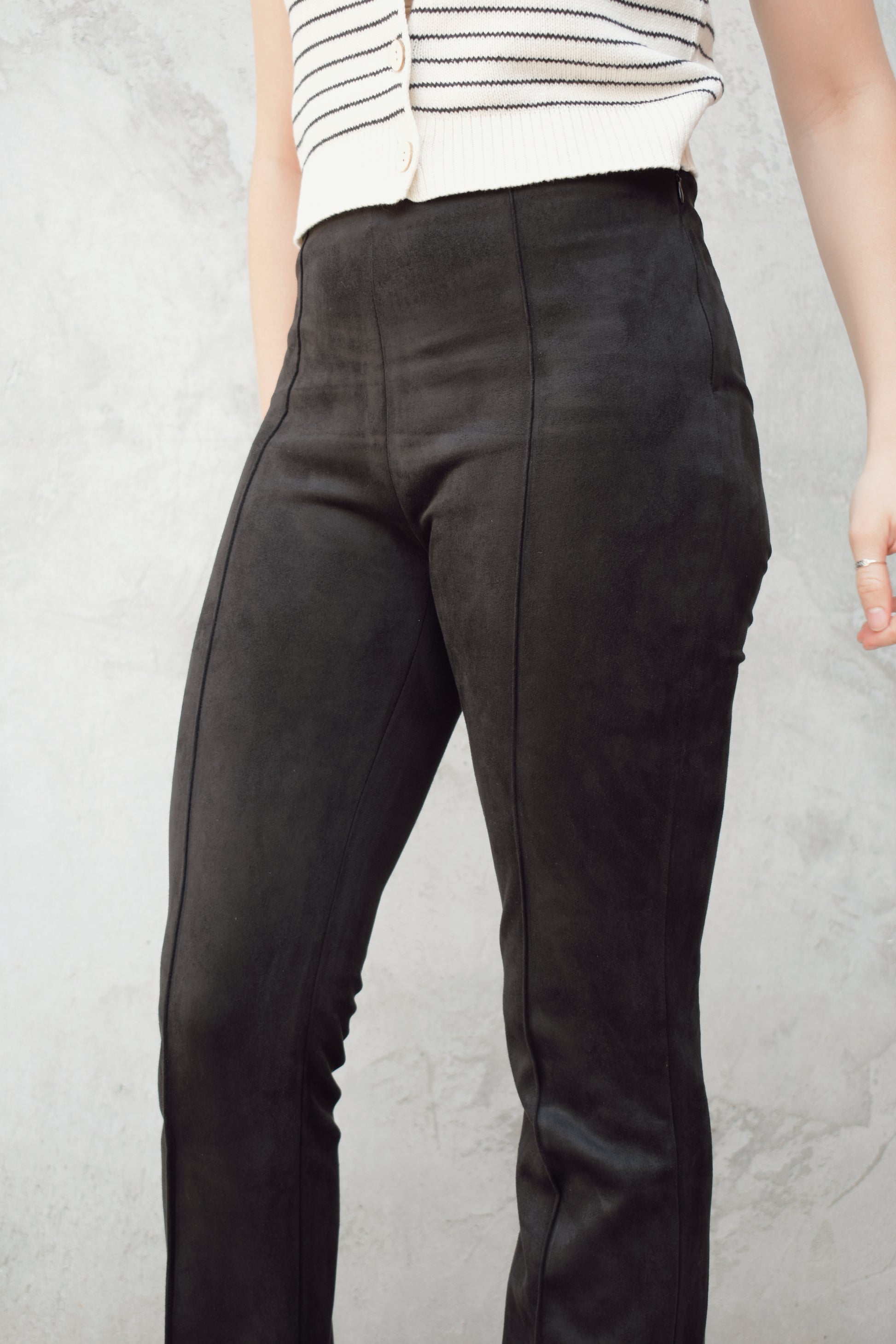 black faux suede pants with a slight cropped kick flare, raised seam detail along front of pant legs, zip side enclosure, high waisted