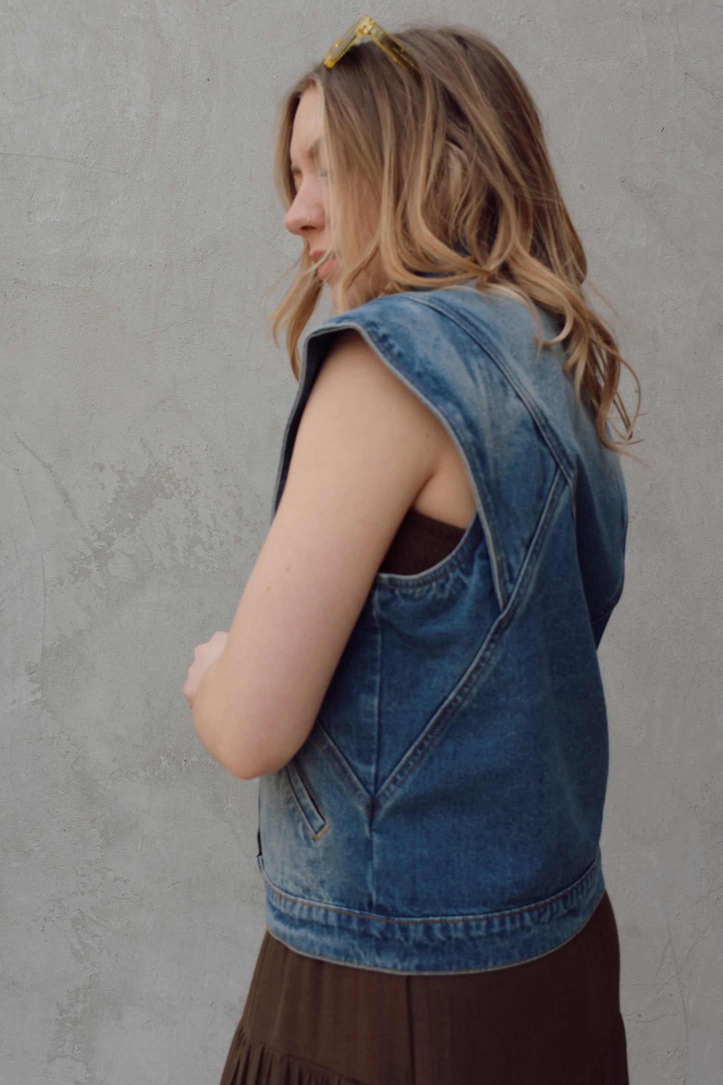 denim full length vest medium wash with some lighter wash marks no holes seam details along front side and back has slit pockets front button enclosure and structured shoulders