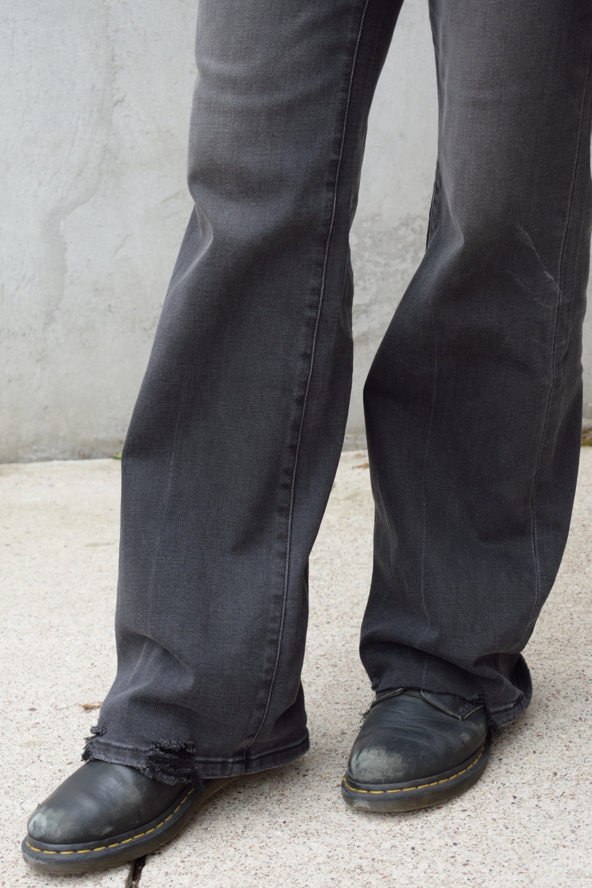 high rise washed black wide leg flare jeans full length stretch denim distressed hem but no holes zip and button enclosure has beltloops has front and back pockets