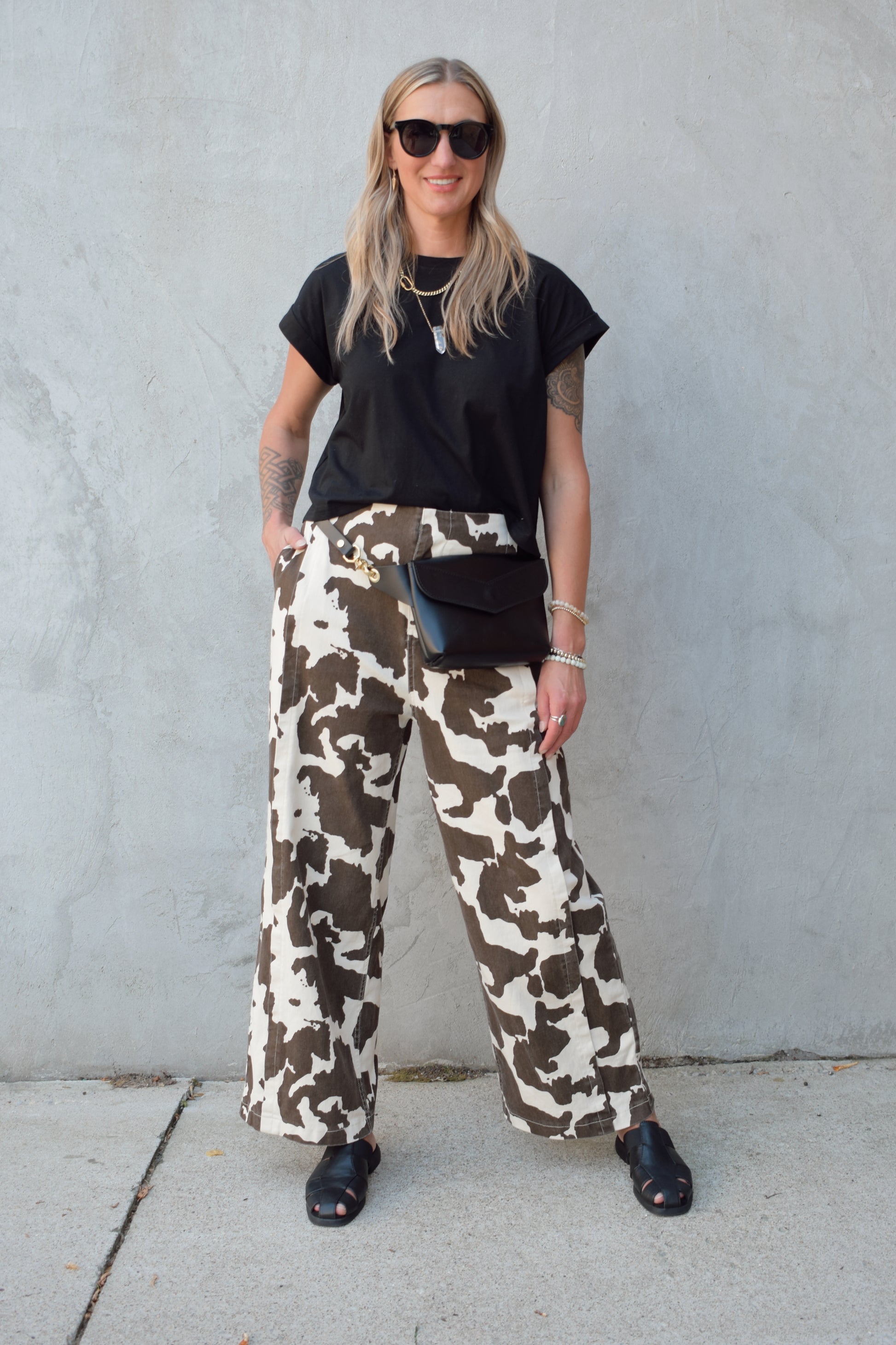 high rise cow print pants with zip and clasp enclosure, seam detailing, elastic on back of waistband, wide leg full length, has front pockets and back pockets
