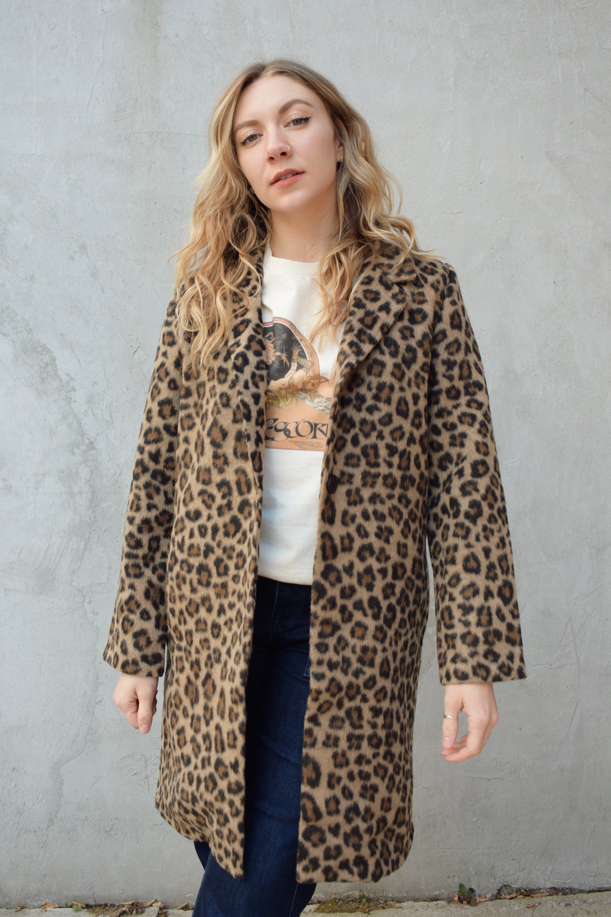 leopard print coat with collar and singular button enclosure has pockets hits just above the knee