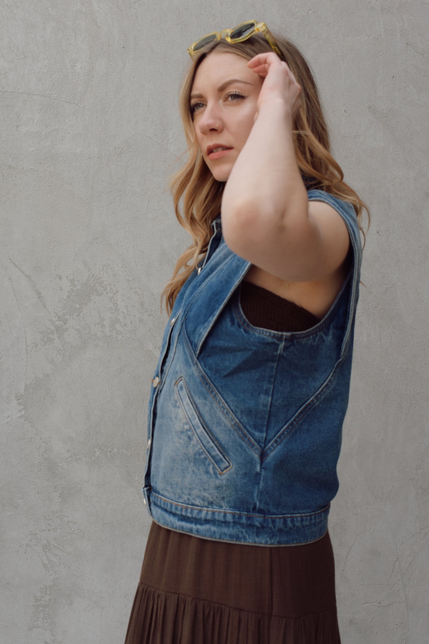denim full length vest medium wash with some lighter wash marks no holes seam details along front side and back has slit pockets front button enclosure and structured shoulders