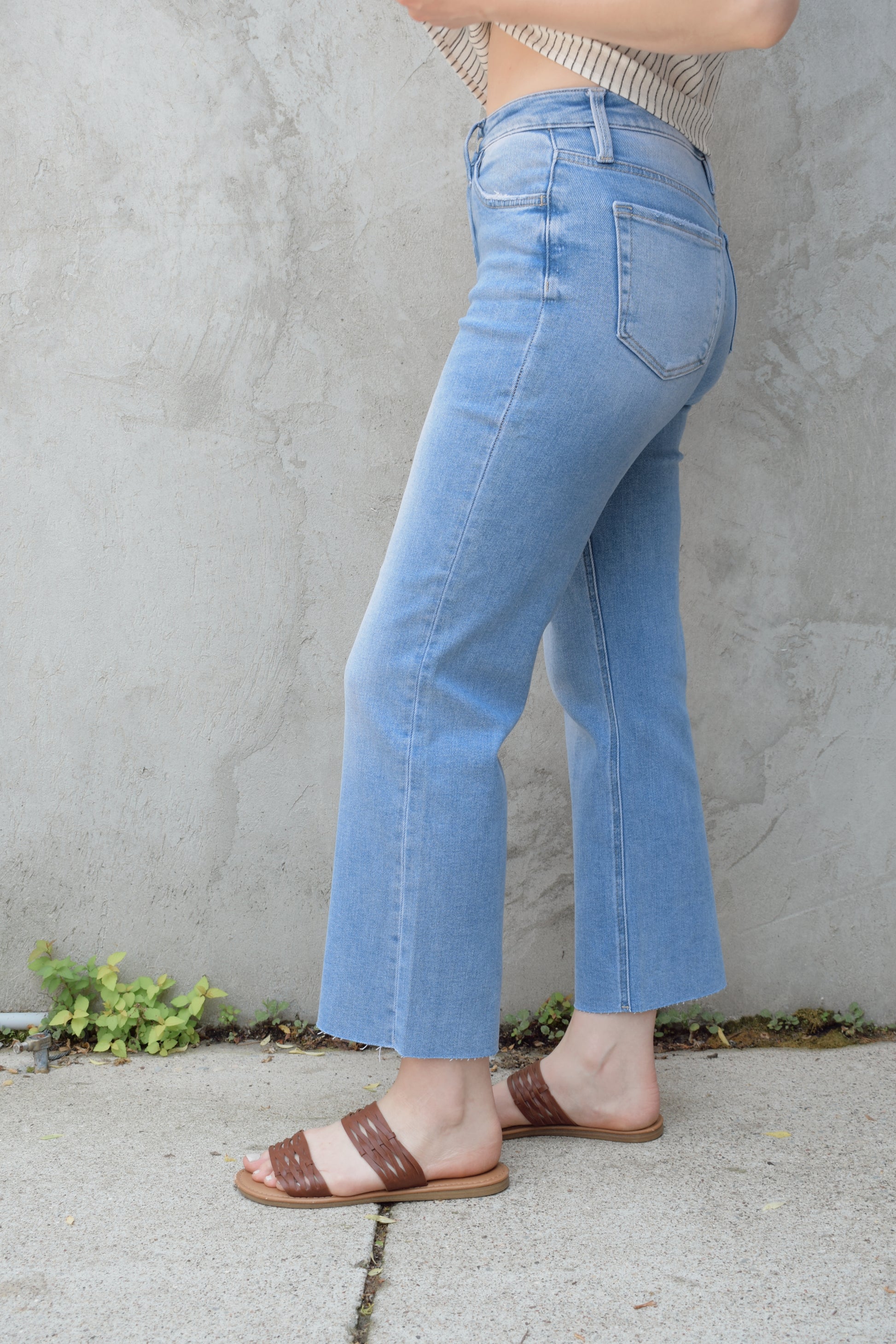 light wash slim wide leg cropped stretch denim with a raw hem and zip and button enclosure has beltloops and front and back pockets, no holes