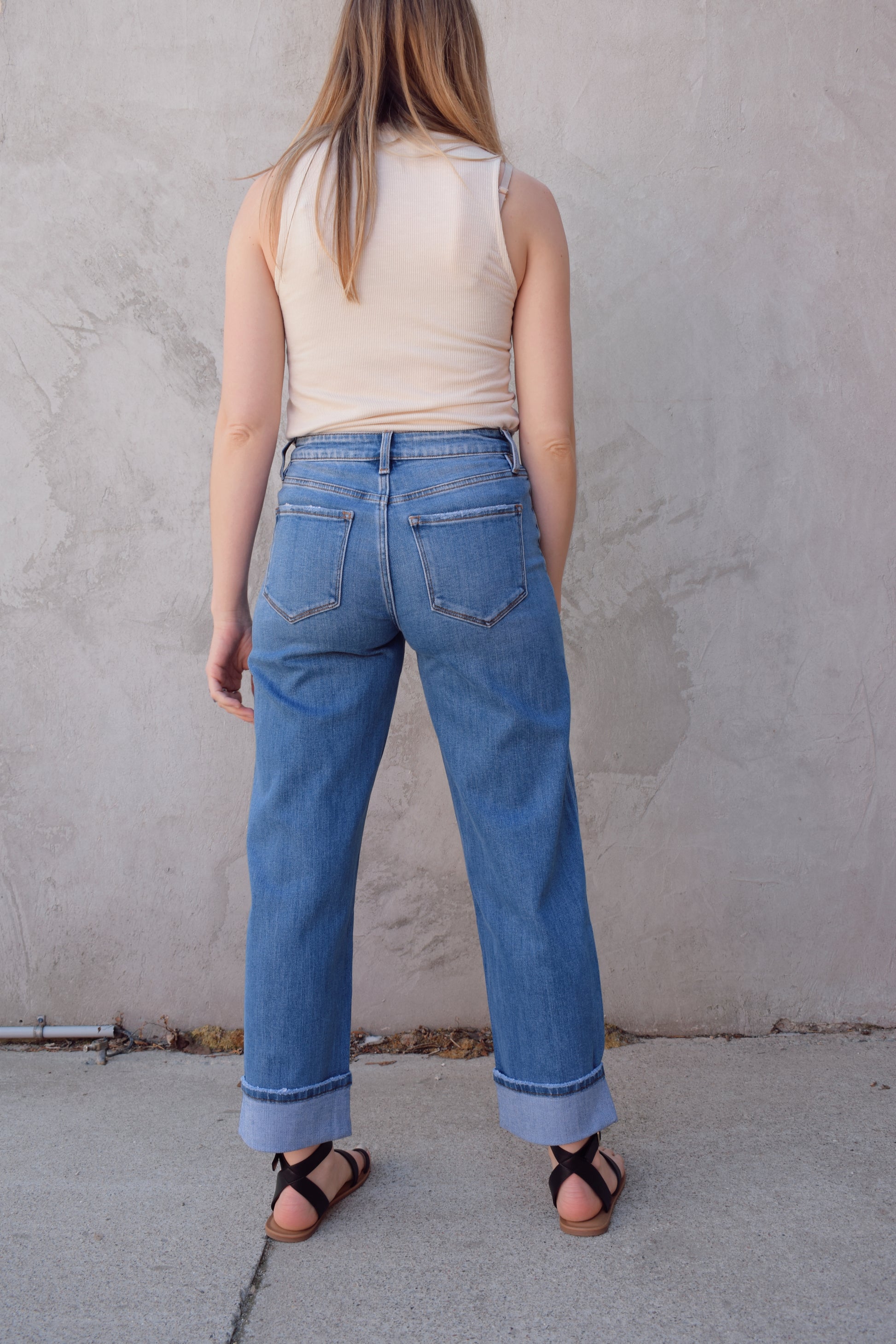 medium wash high rise stretch denim with slight barrel cut, no holes, cuffed, front and back pockets, has beltloops, zip and button enclosure