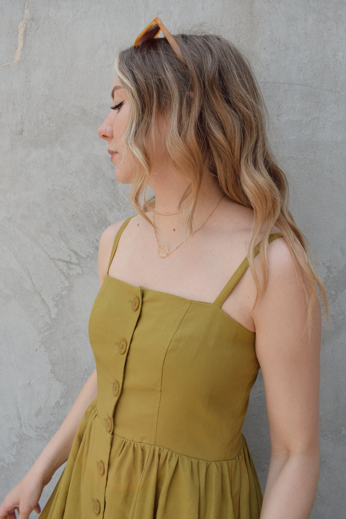 spaghetti strap midi dress with pleats at waistline fitted bodice buttons all down the front that are the same color as the dress, adjustable straps, has pockets, square neckline, smocked panel on back of bodice