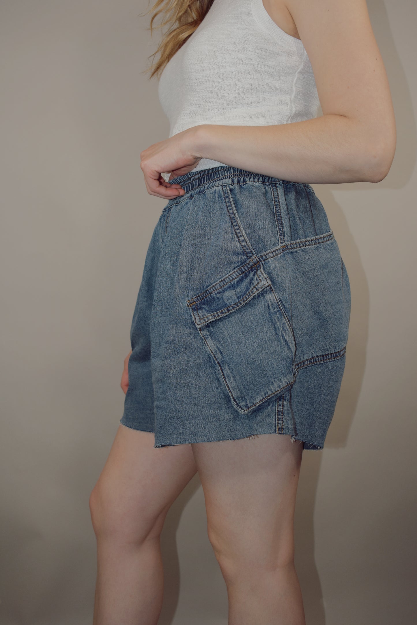 tencel denim effect baggy shorts with raw hem, elastic waistband, cargo pockets along with multiple side pockets, seam detailing, medium wash