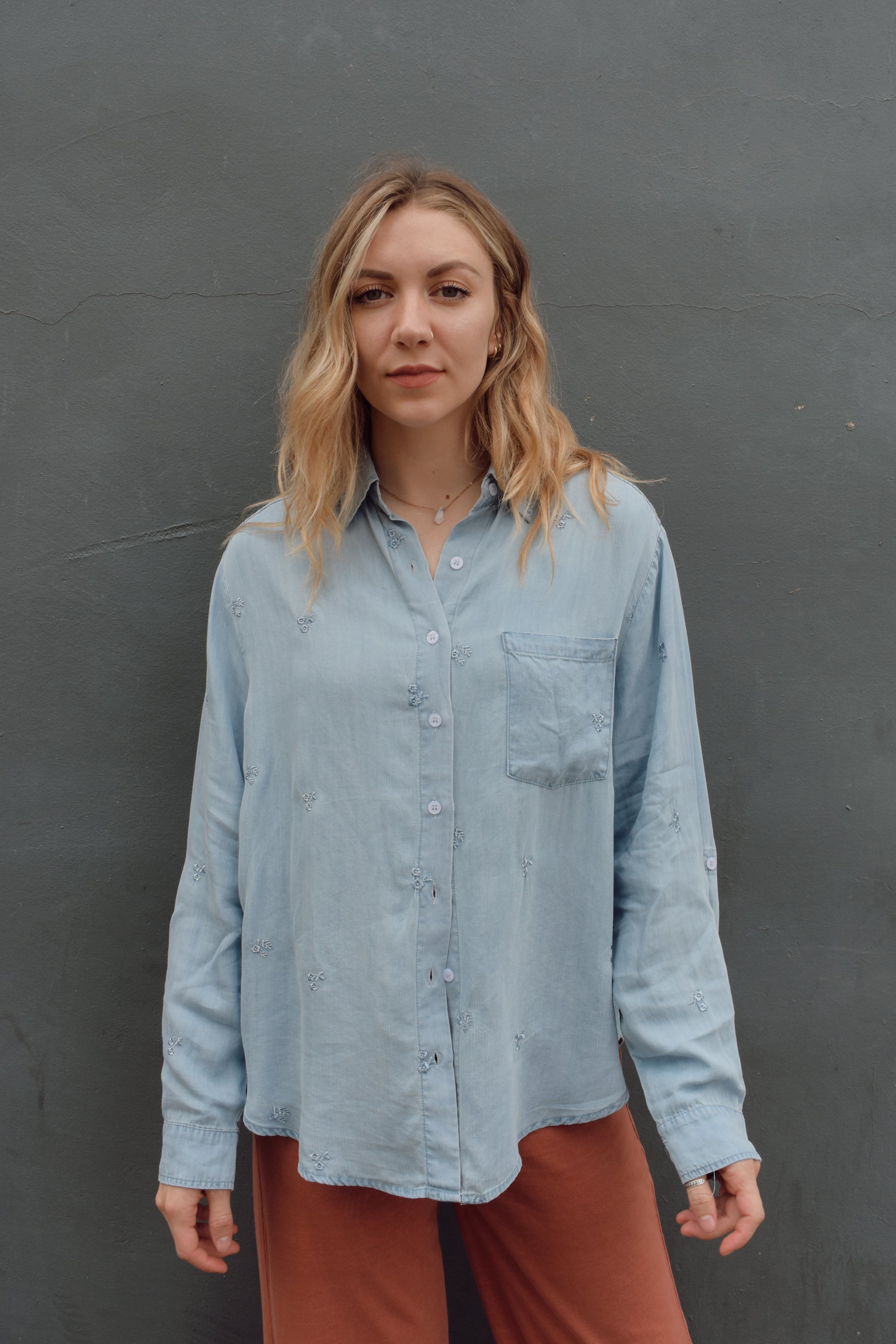 tencel denim chambray button down shirt, oversized relaxed fit, delicate floral embroidery accents same color as button down, one breast patch pocket, sleeves have button for roll up option