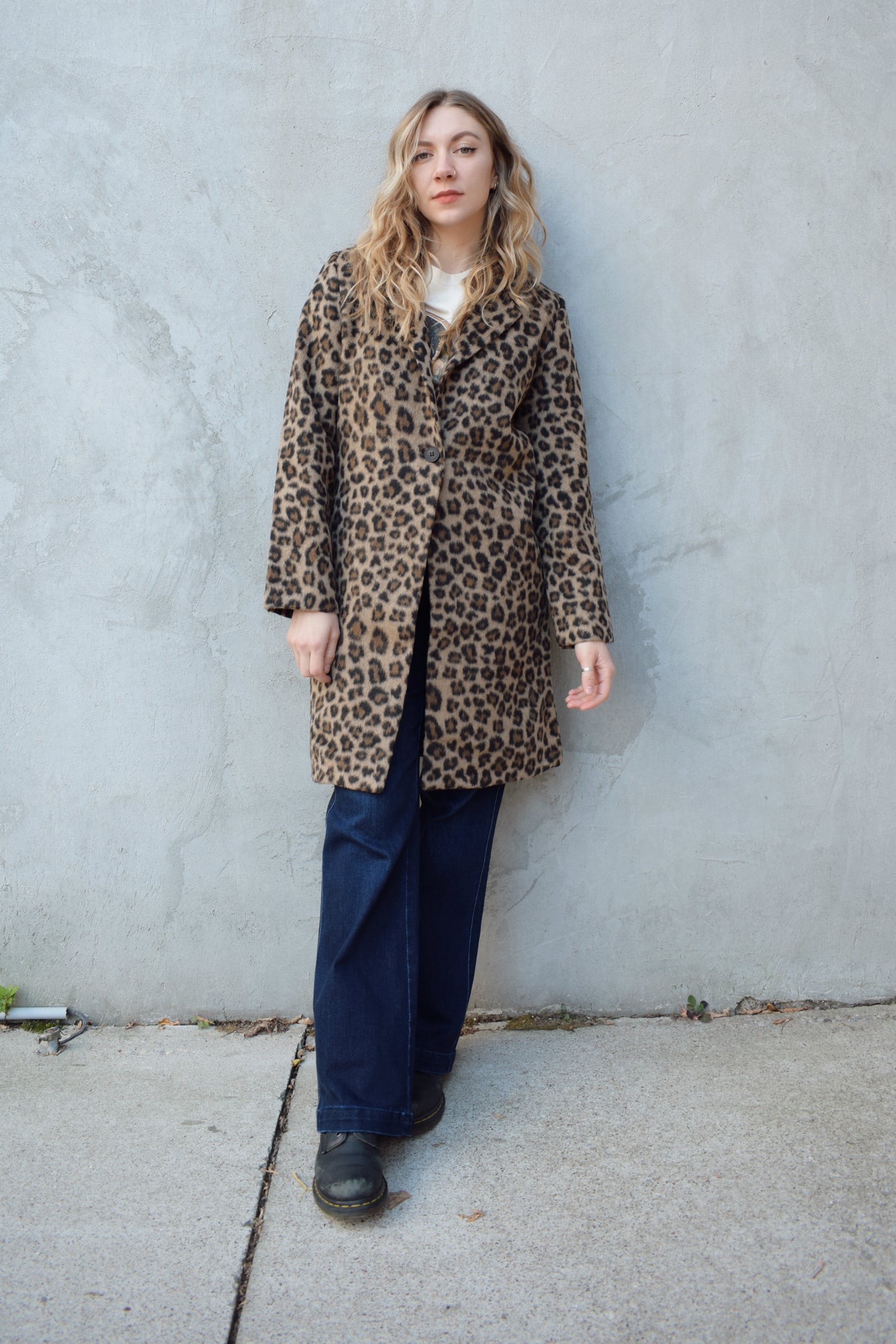 leopard print coat with collar and singular button enclosure has pockets hits just above the knee