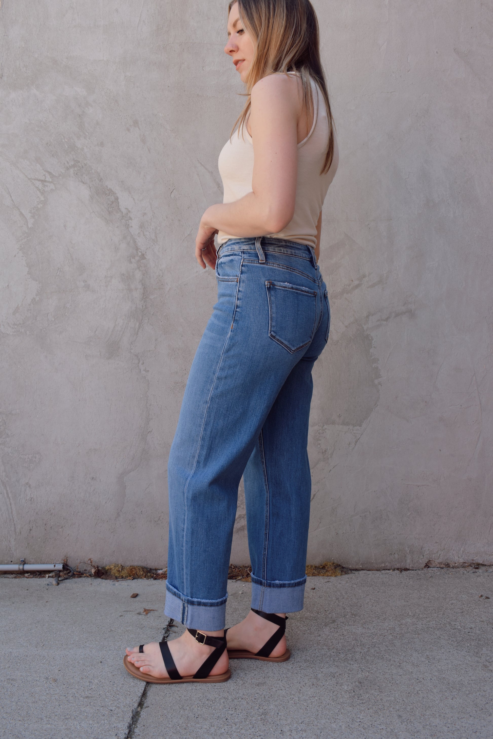 medium wash high rise stretch denim with slight barrel cut, no holes, cuffed, front and back pockets, has beltloops, zip and button enclosure