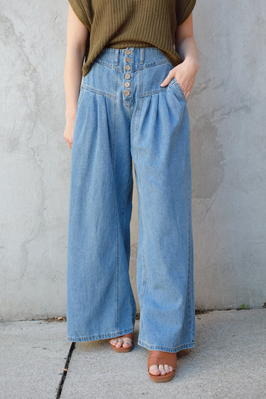 high waisted palazzo jeans light weight has pockets dropped yoke seam and pleats wooden button front enclosure elastic back of waistband no back pockets has beltloops