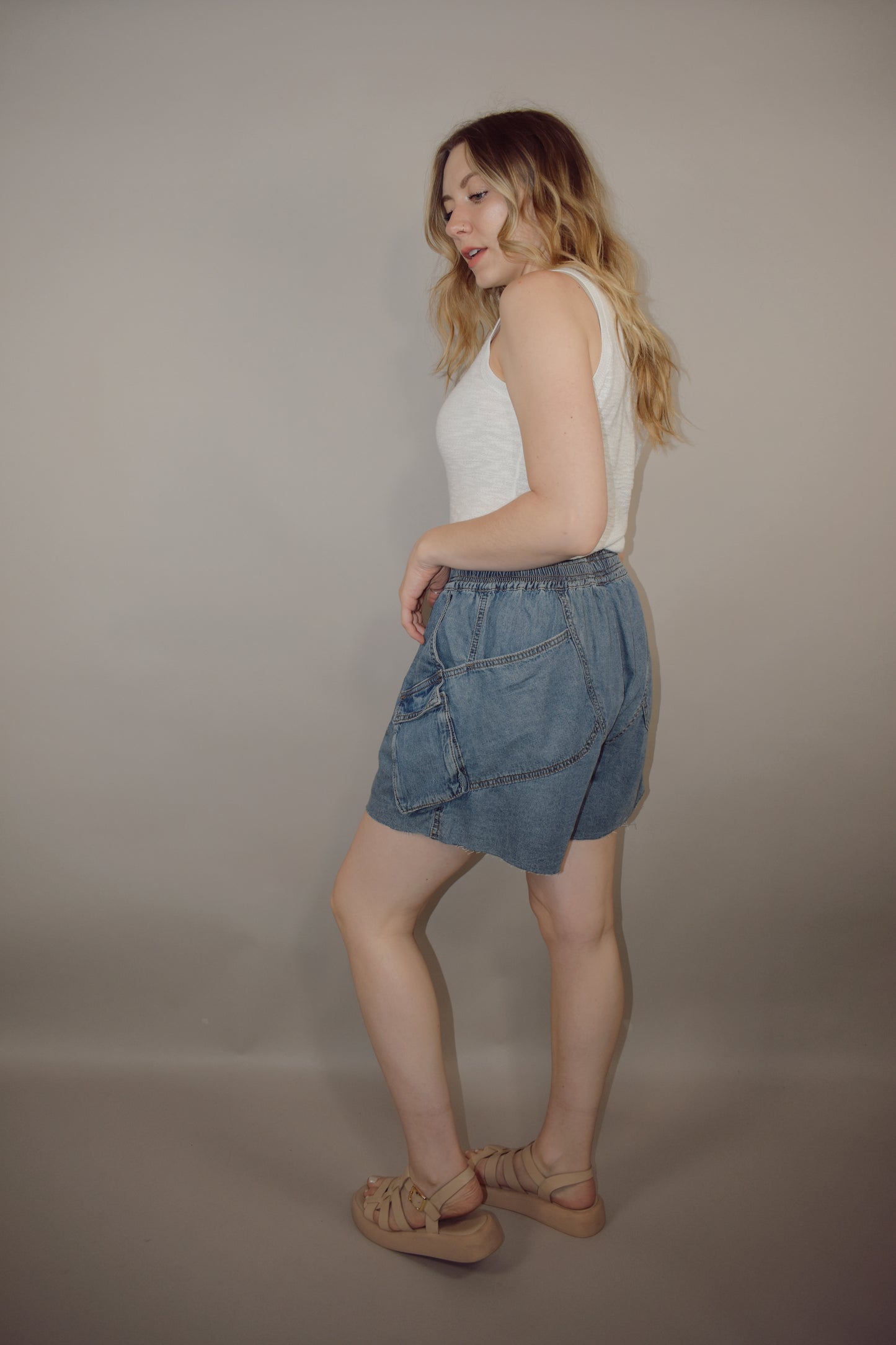 tencel denim effect baggy shorts with raw hem, elastic waistband, cargo pockets along with multiple side pockets, seam detailing, medium wash