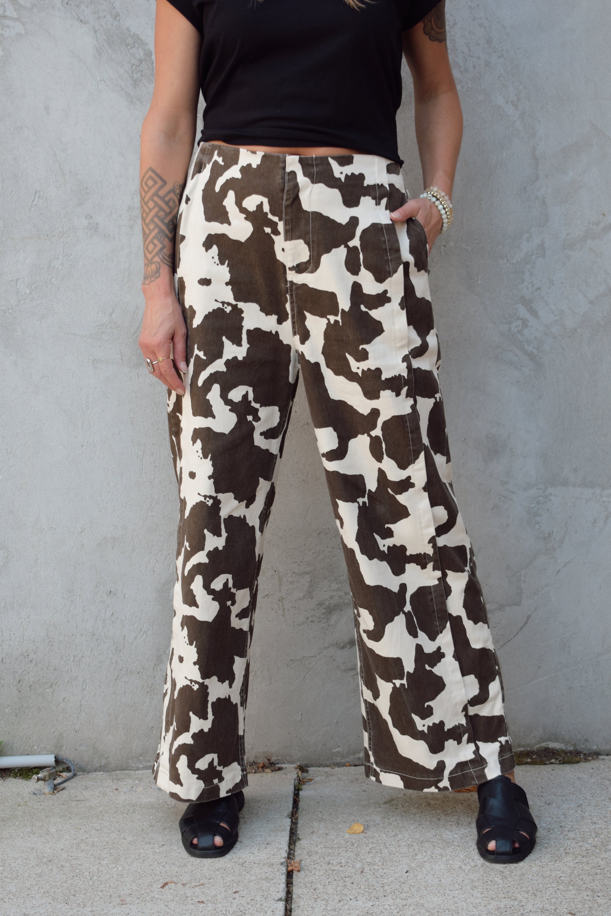 high rise cow print pants with zip and clasp enclosure, seam detailing, elastic on back of waistband, wide leg full length, has front pockets and back pockets