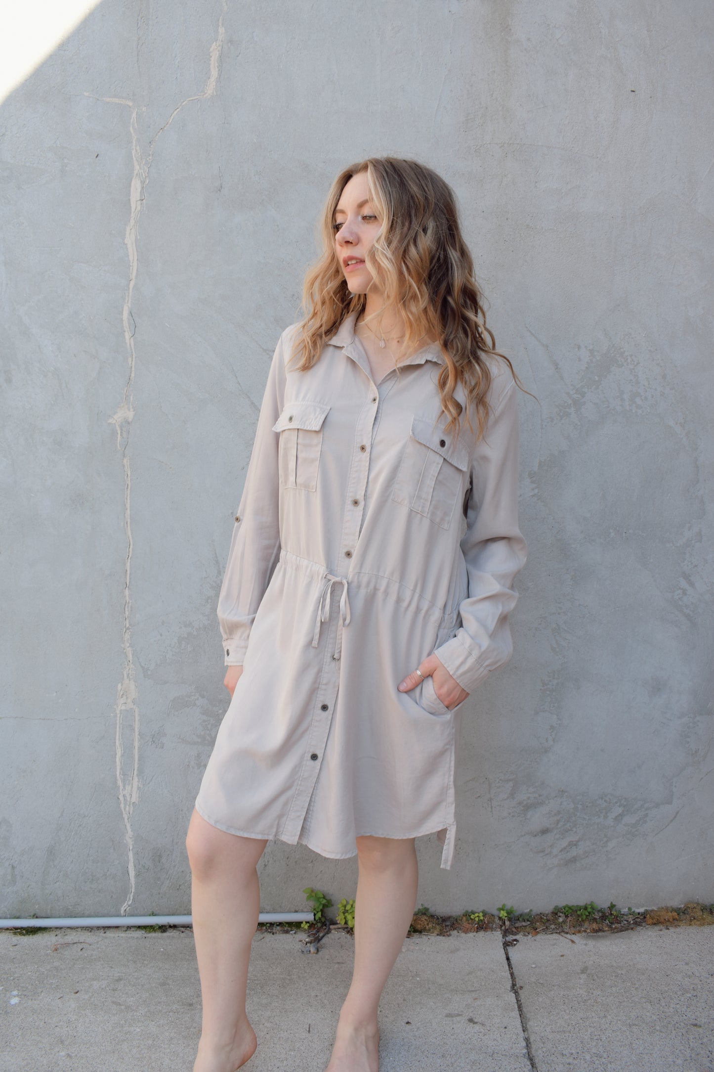 tencel utility long sleeve mini dress with cuff and button sleeves, button down front enclosure, drawstring at waist, breast utility patch pockets with flap and button enclosure, has side pockets, scoop and side slit hem, loose fit