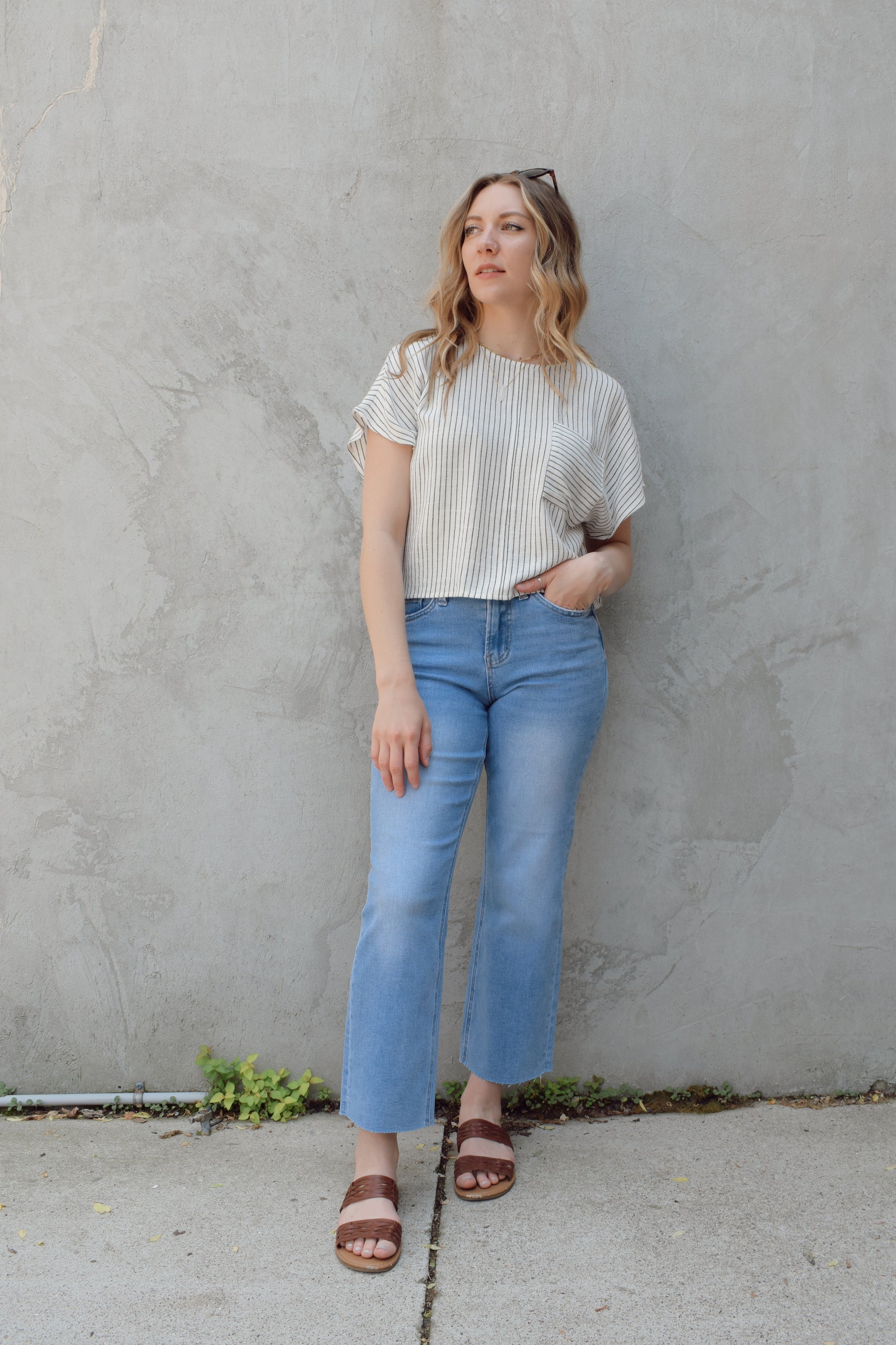 light wash slim wide leg cropped stretch denim with a raw hem and zip and button enclosure has beltloops and front and back pockets, no holes