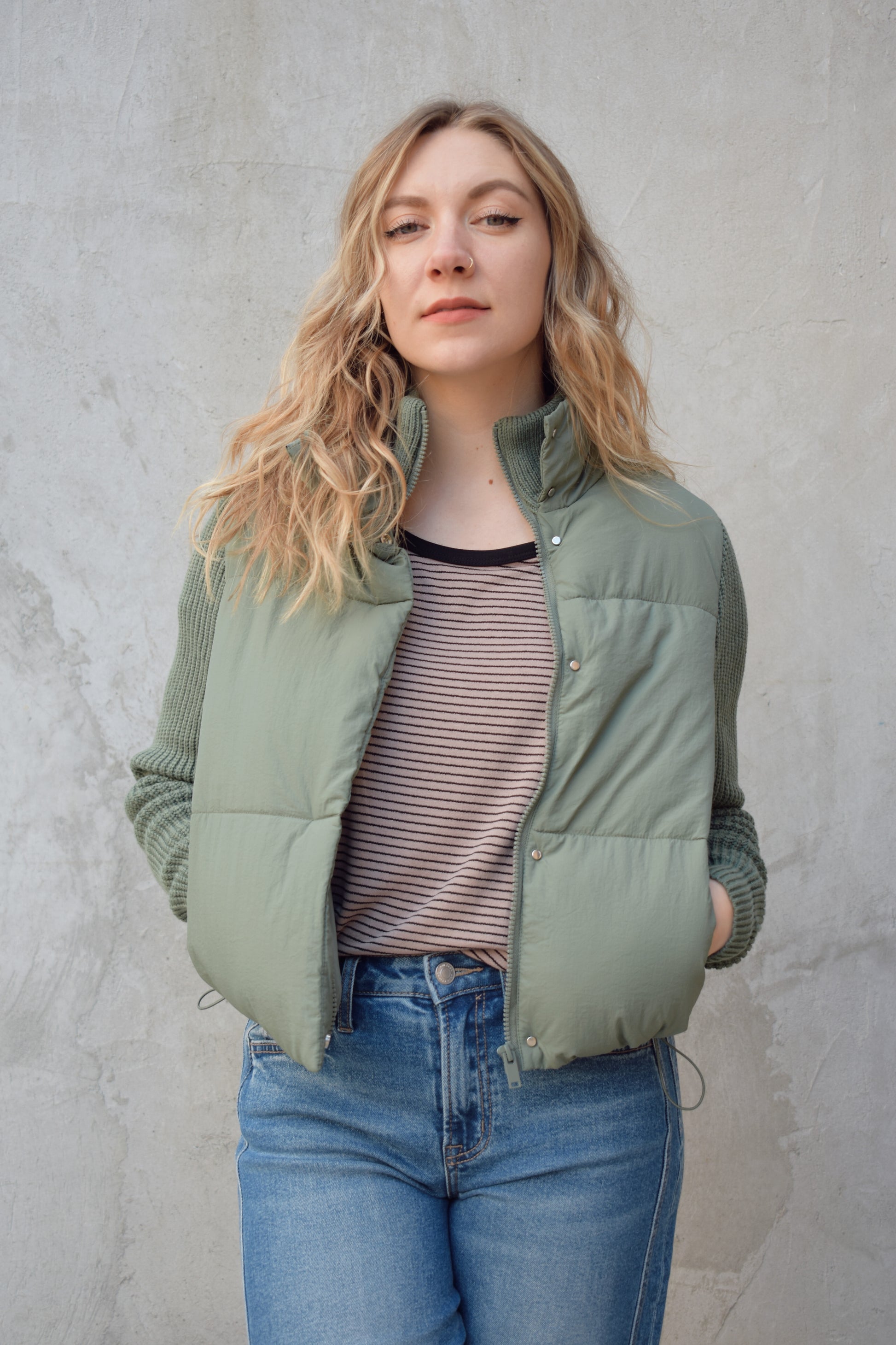 blue green puffer jacket with ribbed knit sleeves, zip and snap front enclosure, has double collar with both materials, has pockets, sinch band at hem