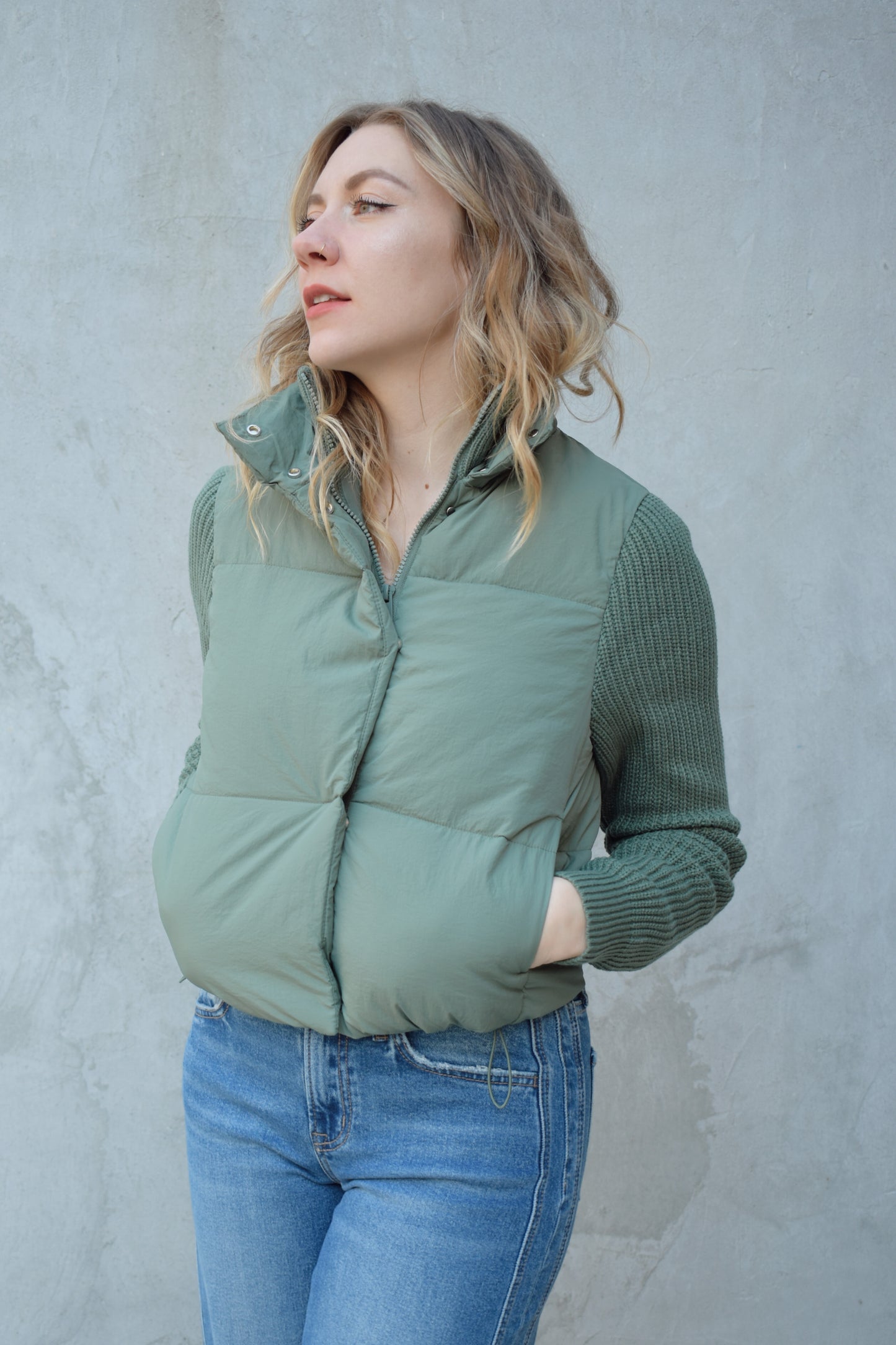 blue green puffer jacket with ribbed knit sleeves, zip and snap front enclosure, has double collar with both materials, has pockets, sinch band at hem