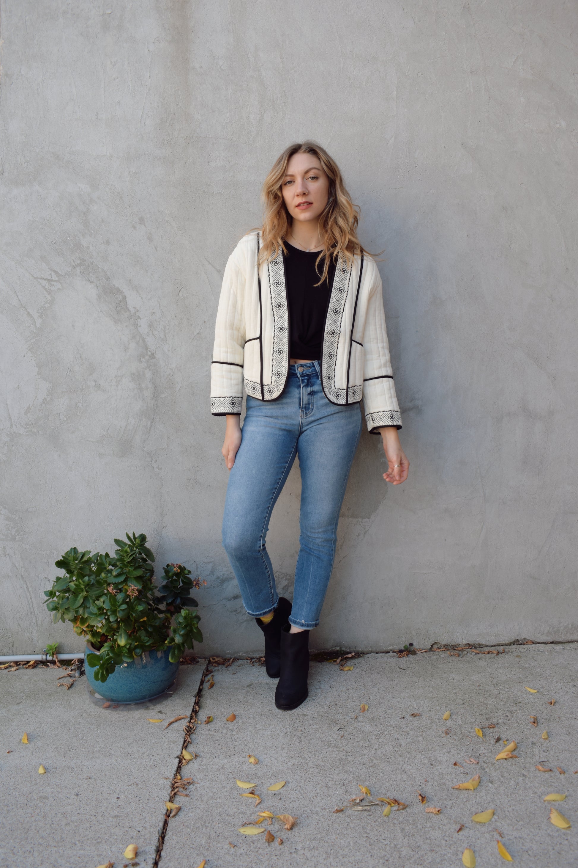 boho quilted ivory jacket with black exposed seam detailing and design along hem, has pockets, 2 clasp enclosure