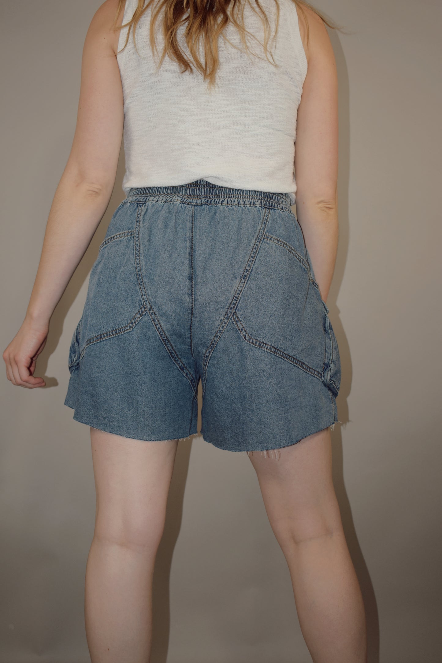tencel denim effect baggy shorts with raw hem, elastic waistband, cargo pockets along with multiple side pockets, seam detailing, medium wash