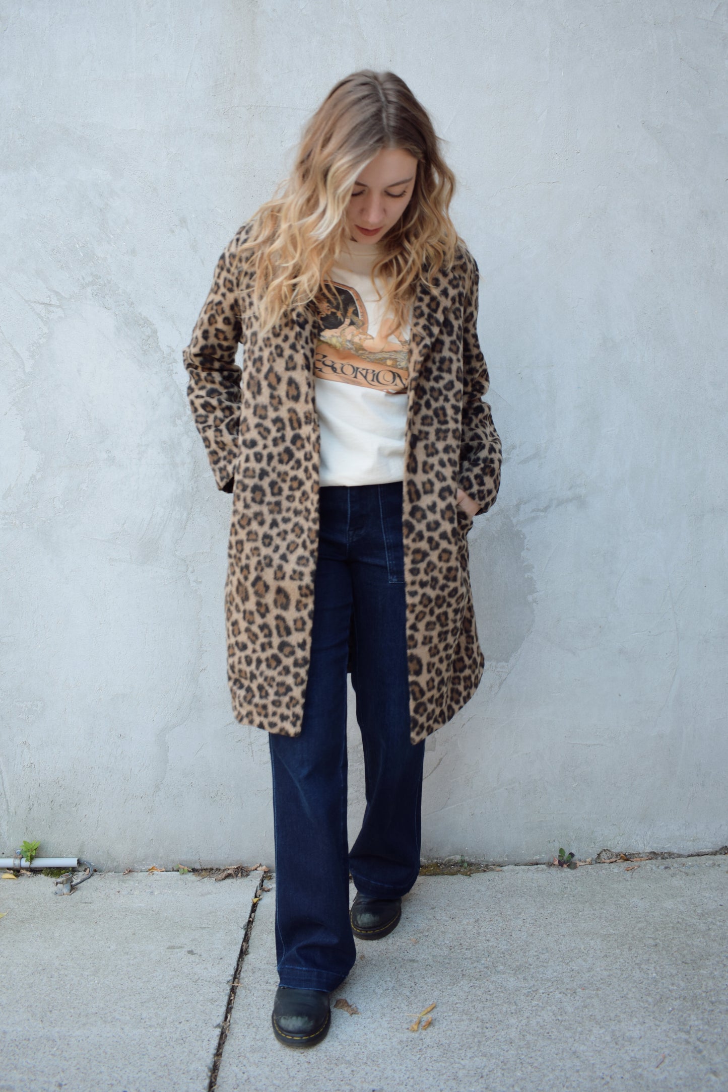 leopard print coat with collar and singular button enclosure has pockets hits just above the knee
