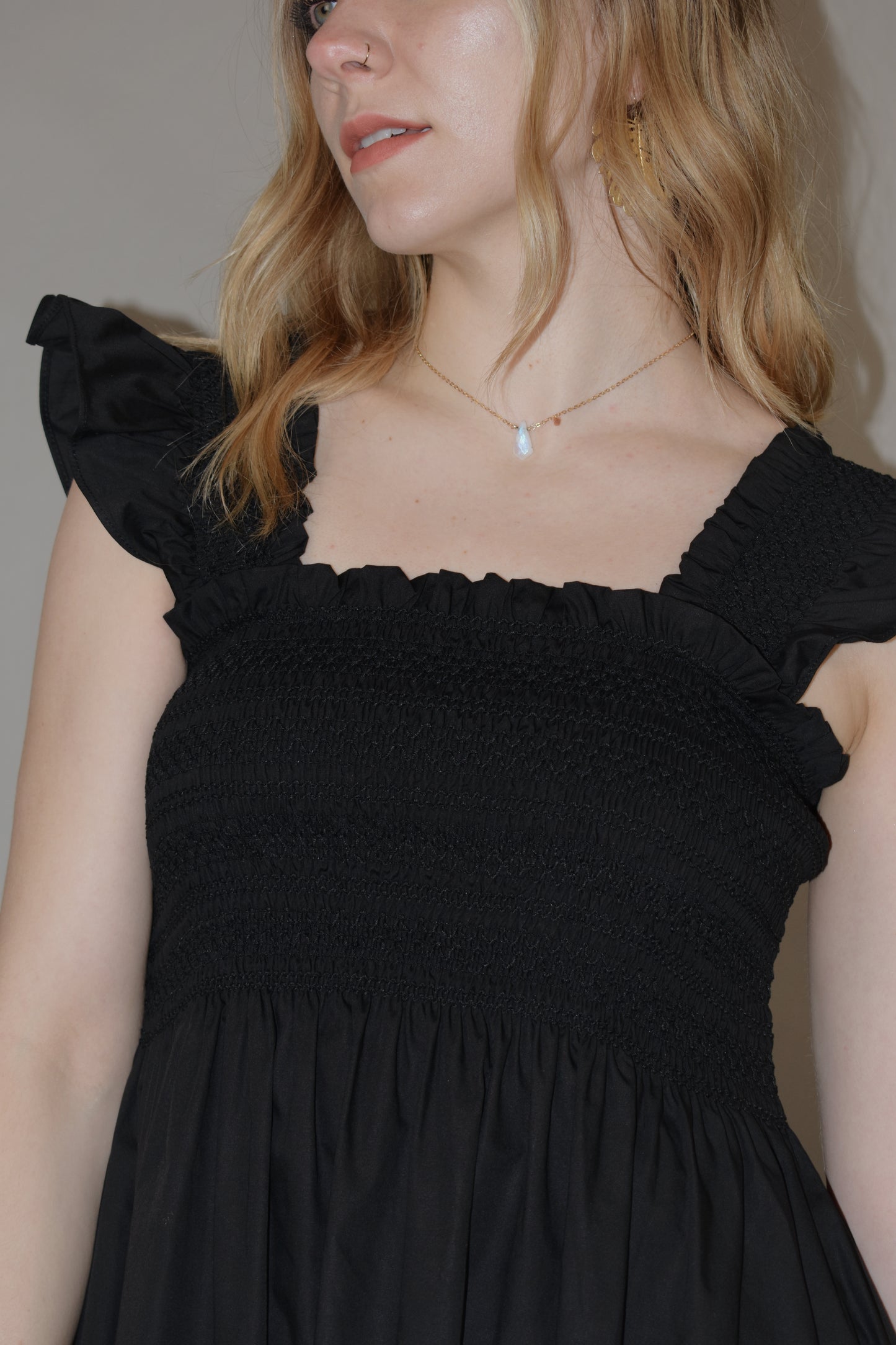 black midi dress with cream embroidered flower vine along hem, smocked bodice, square neckline, flutter shoulder detail, flowy yet tailored feel
