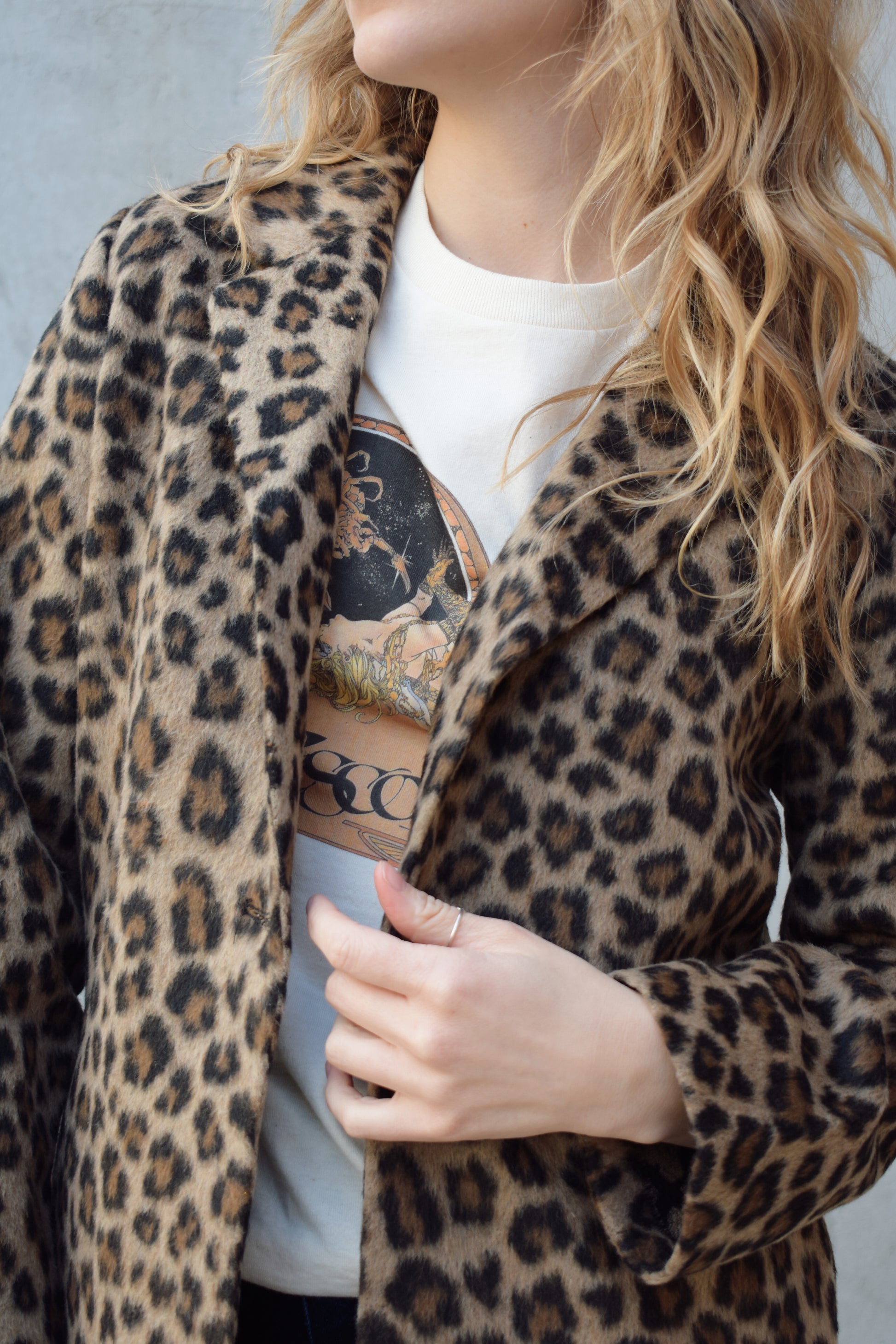 leopard print coat with collar and singular button enclosure has pockets hits just above the knee