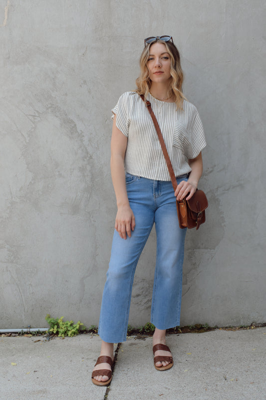 light wash slim wide leg cropped stretch denim with a raw hem and zip and button enclosure has beltloops and front and back pockets, no holes