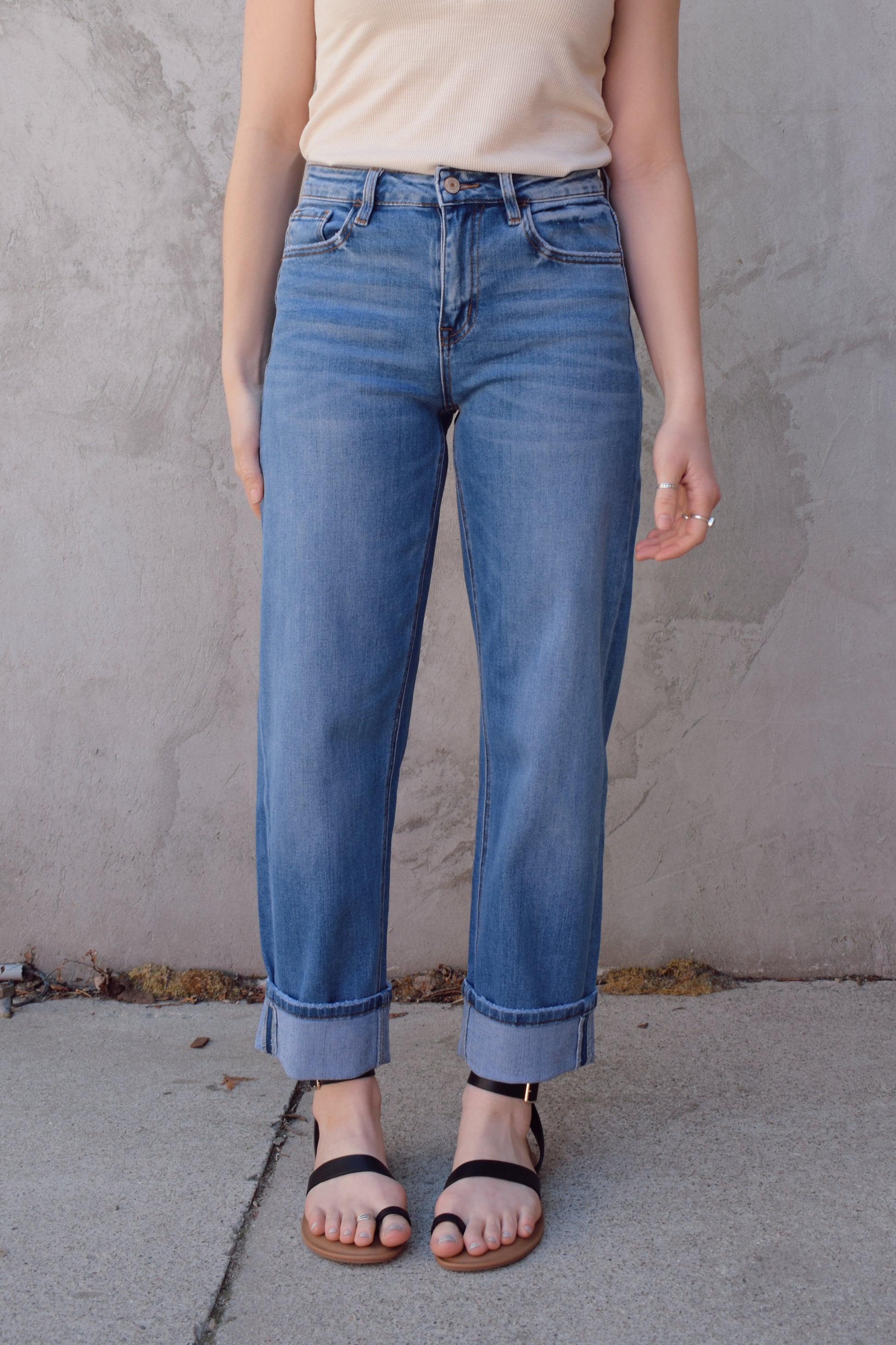 medium wash high rise stretch denim with slight barrel cut, no holes, cuffed, front and back pockets, has beltloops, zip and button enclosure