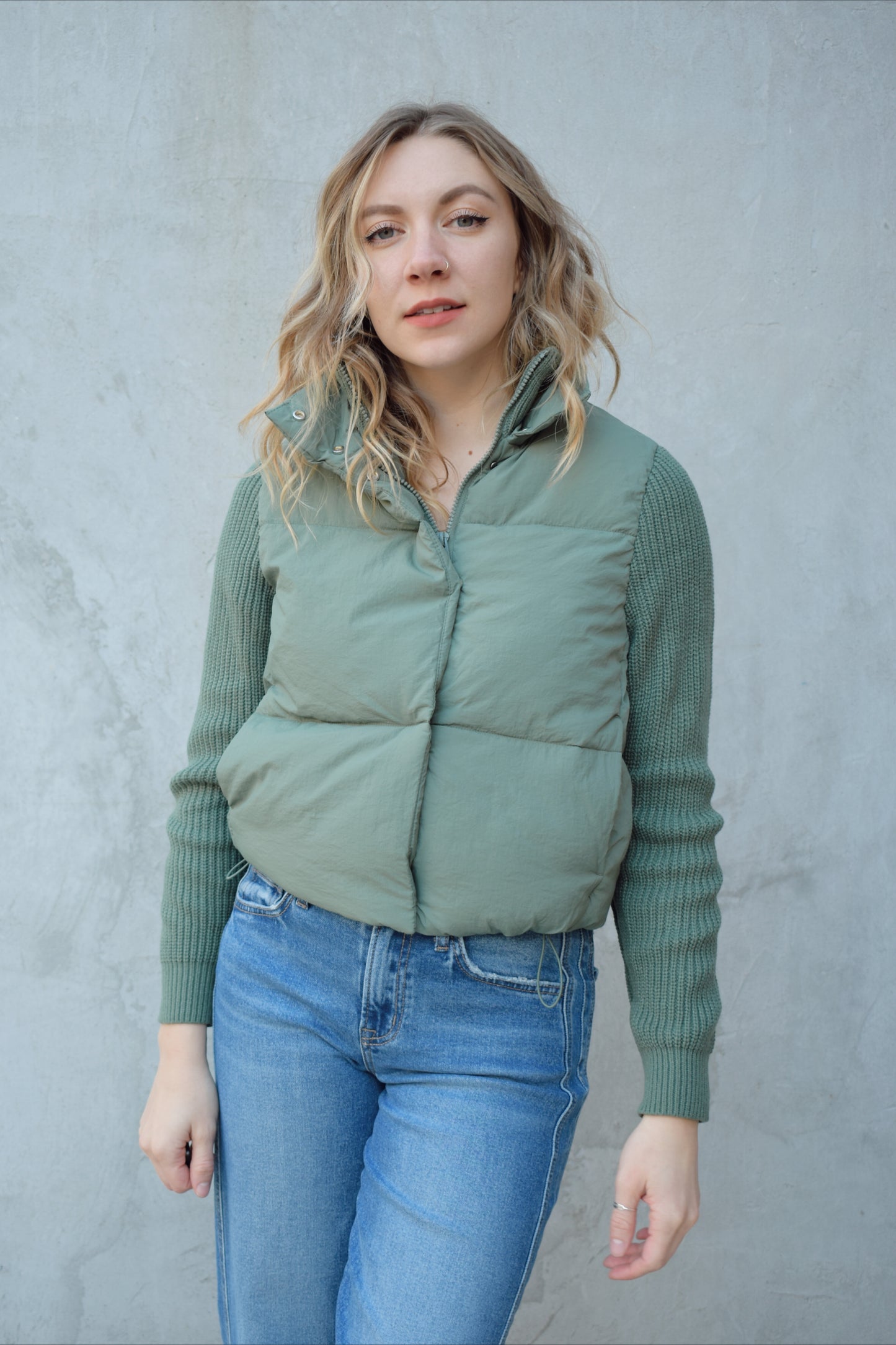 blue green puffer jacket with ribbed knit sleeves, zip and snap front enclosure, has double collar with both materials, has pockets, sinch band at hem