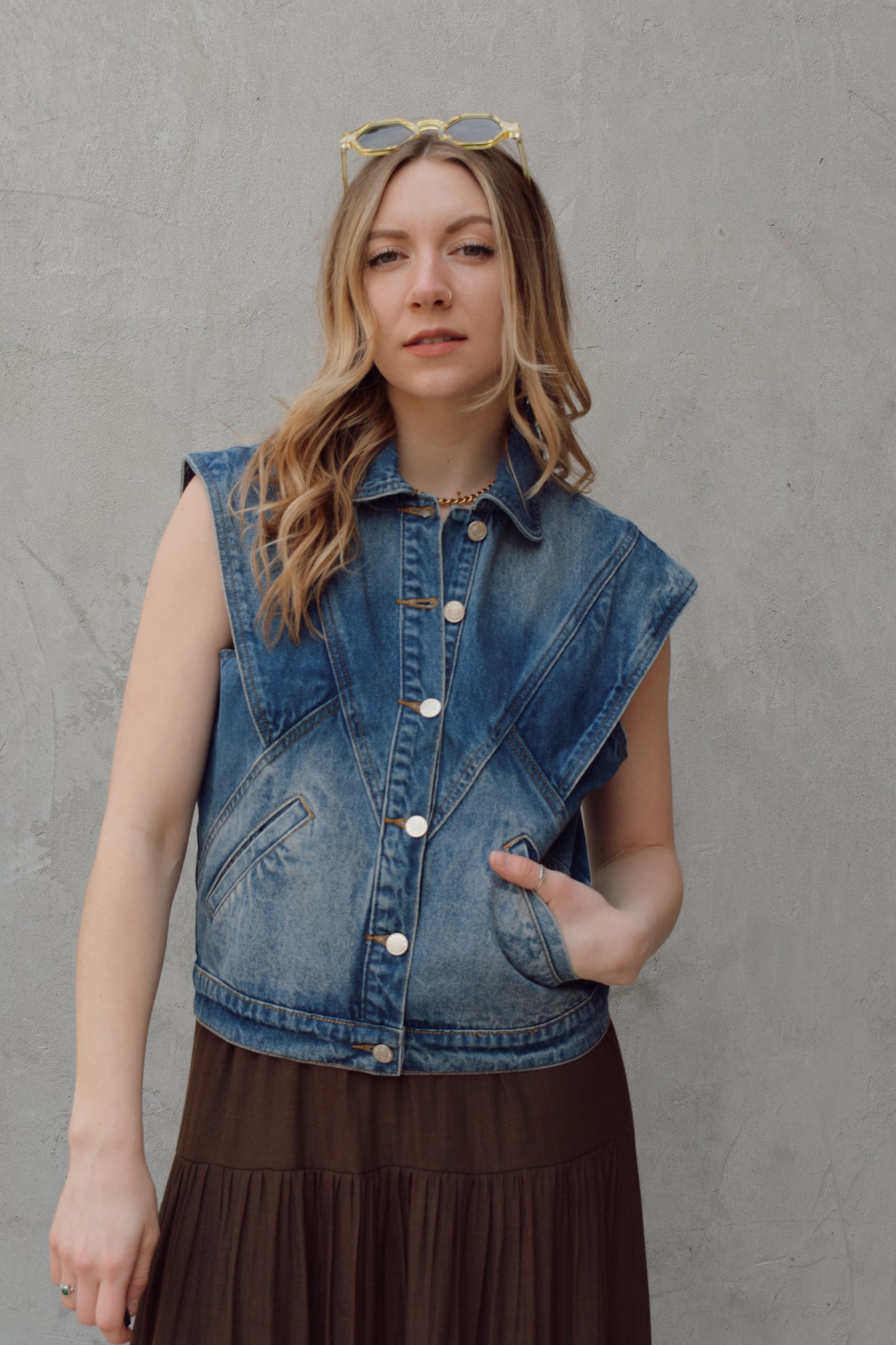 denim full length vest medium wash with some lighter wash marks no holes seam details along front side and back has slit pockets front button enclosure and structured shoulders