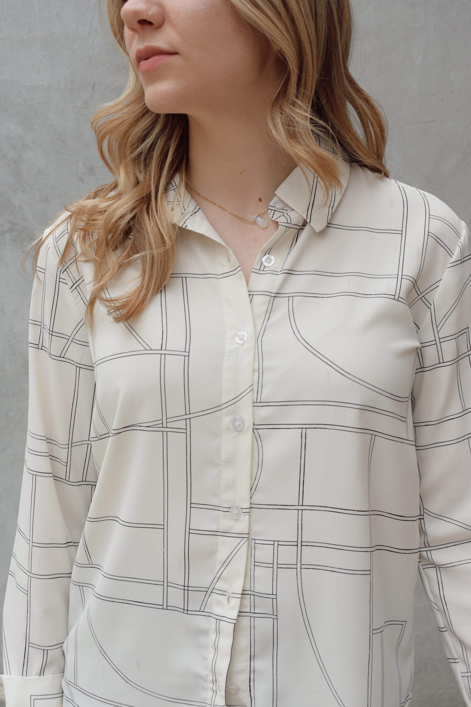 lightweight long sleeve off white button down blouse that has a chic geometric pattern, fitted cuffs, full length straight fit