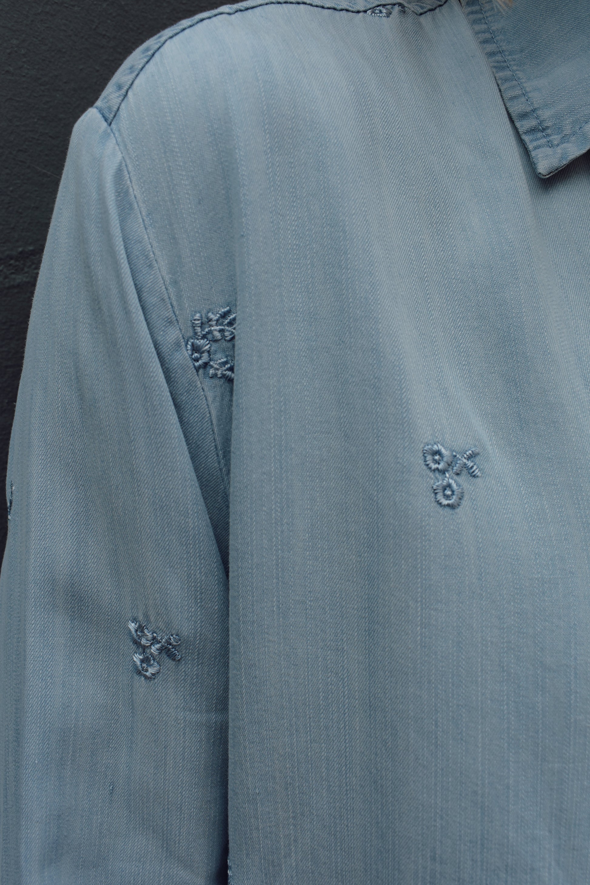tencel denim chambray button down shirt, oversized relaxed fit, delicate floral embroidery accents same color as button down, one breast patch pocket, sleeves have button for roll up option