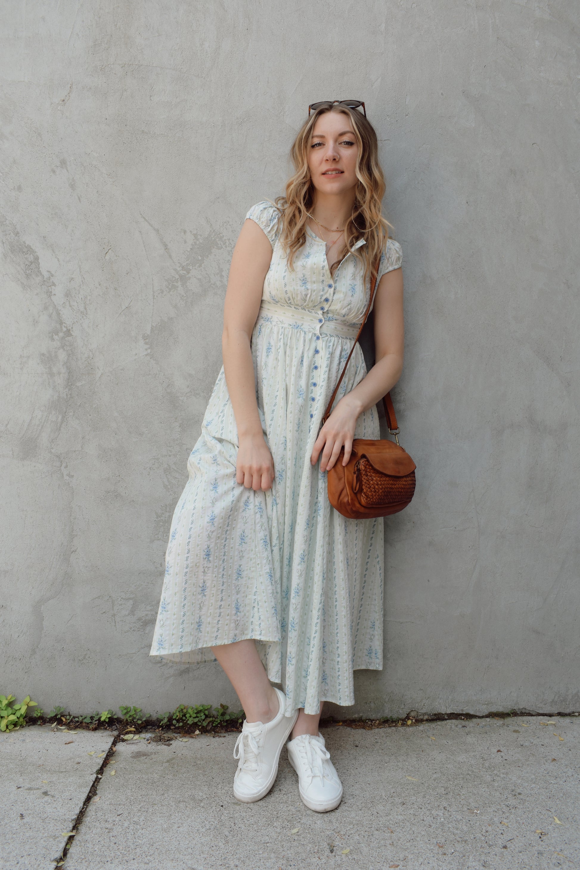 cap sleeve midi dress with ditsy floral pattern and blue buttons down the front until hitting a slit in front hem, fitted waist with smocked band in back, v neck, twirly