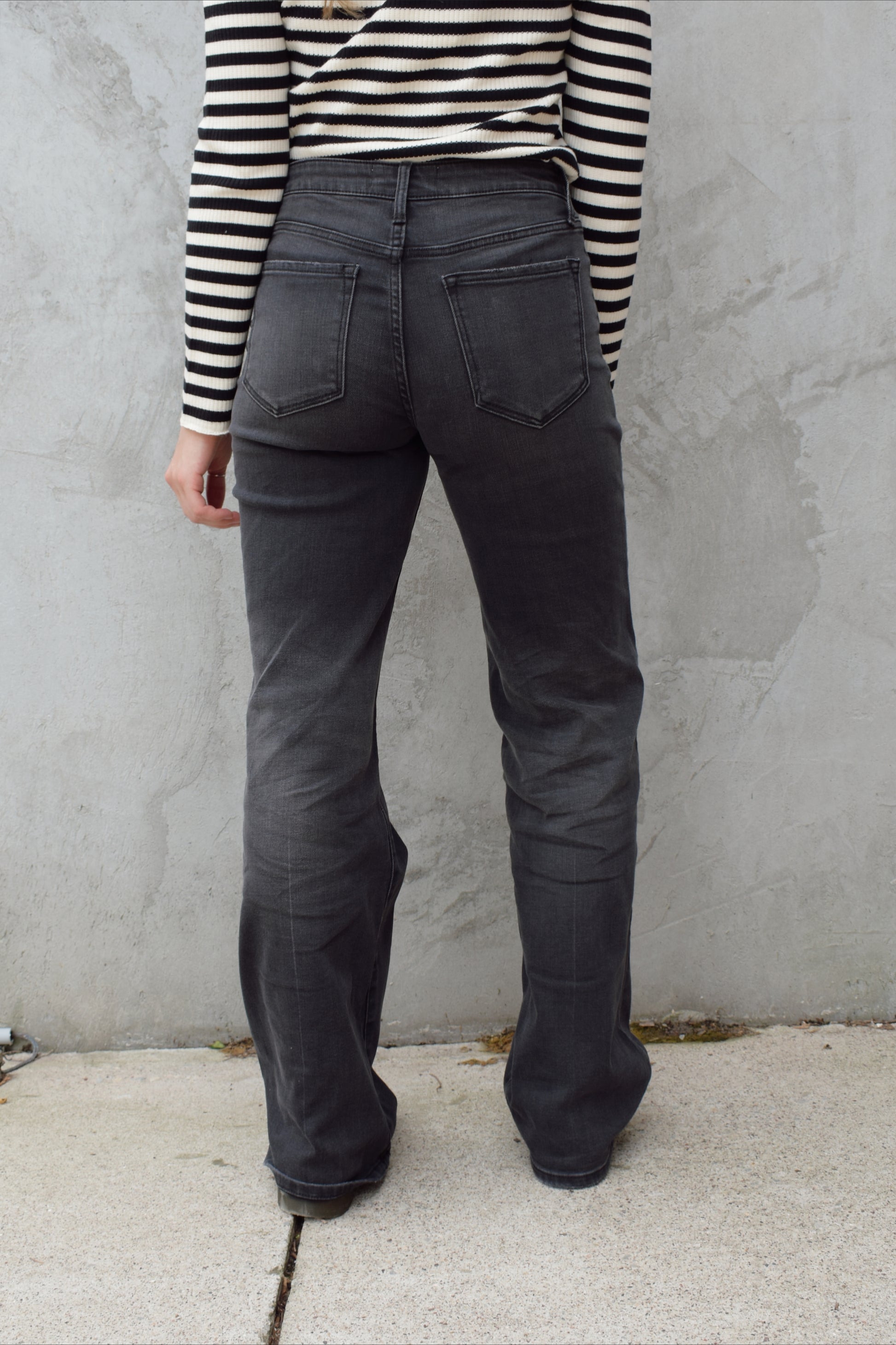 high rise washed black wide leg flare jeans full length stretch denim distressed hem but no holes zip and button enclosure has beltloops has front and back pockets