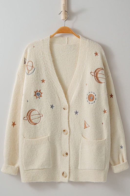 cream slouchy v neck button down cardigan hits just below hips and is embroidered with stars moons and suns has front patch pockets and drop shoulders