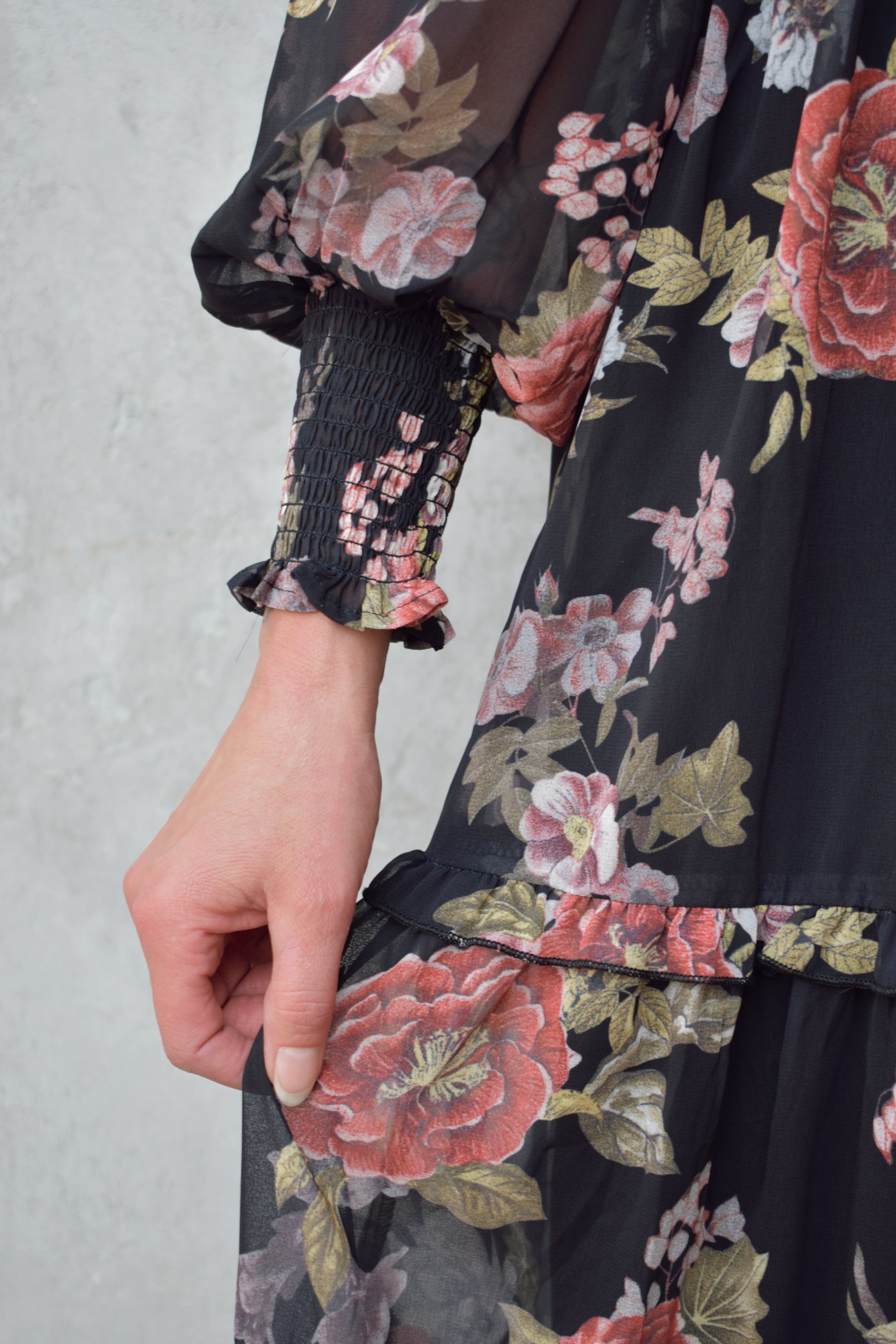 dressy floral midi dress with black background, chiffon material with sheer long sleeves, smocking on bodice and cuffs, high neck, tiered skirt.