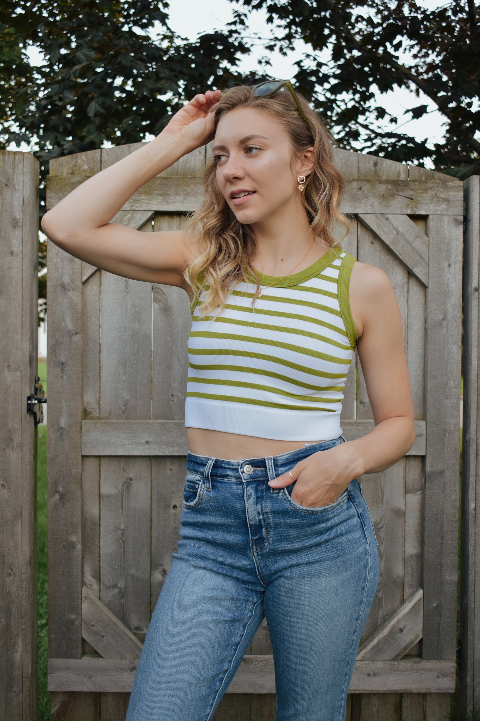 cropped tank with horizontal stripes. thick band of white around bottom hem. arm and neck line hem are solid color. crew neck. stretchy. 