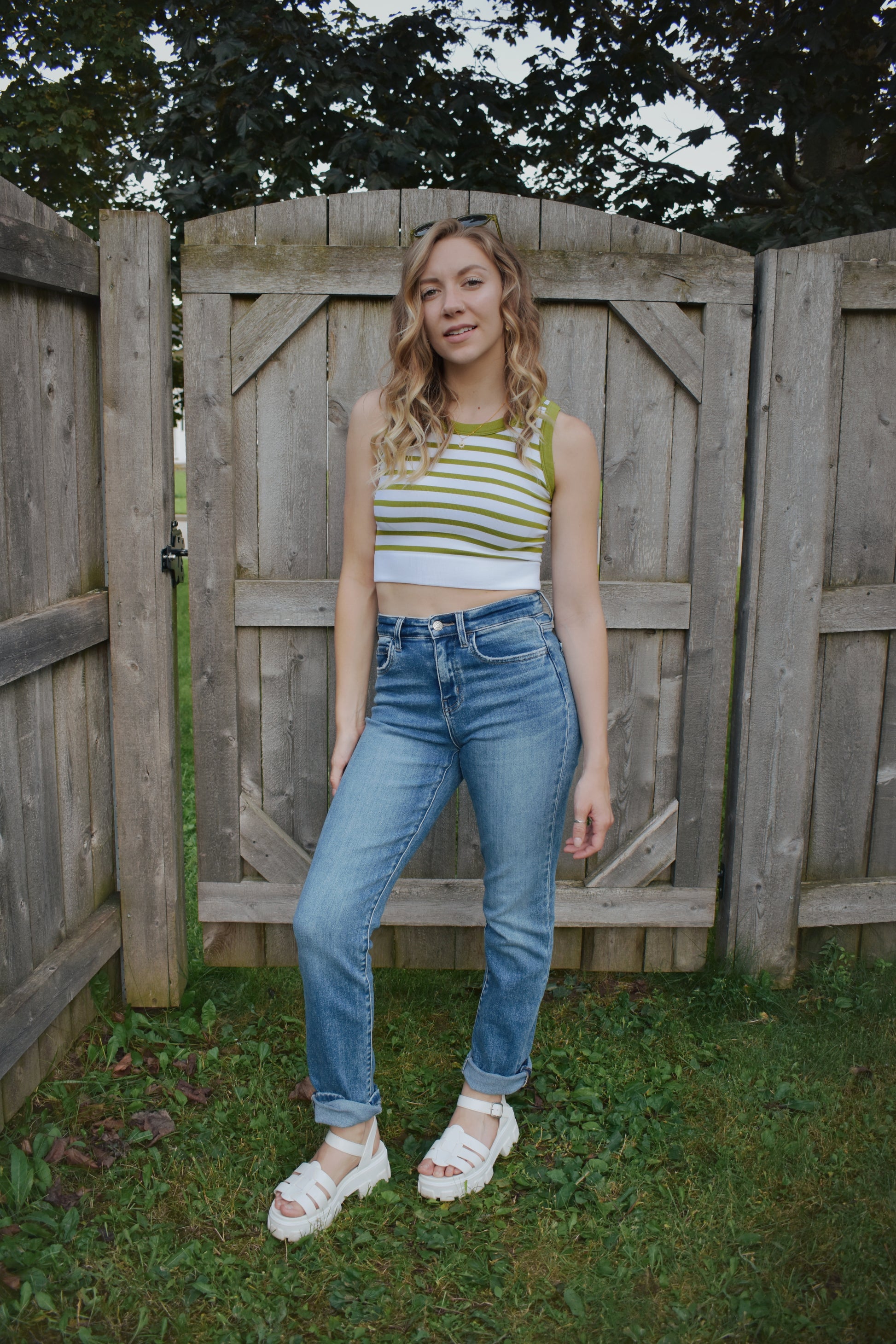 cropped tank with horizontal stripes. thick band of white around bottom hem. arm and neck line hem are solid color. crew neck. stretchy. 