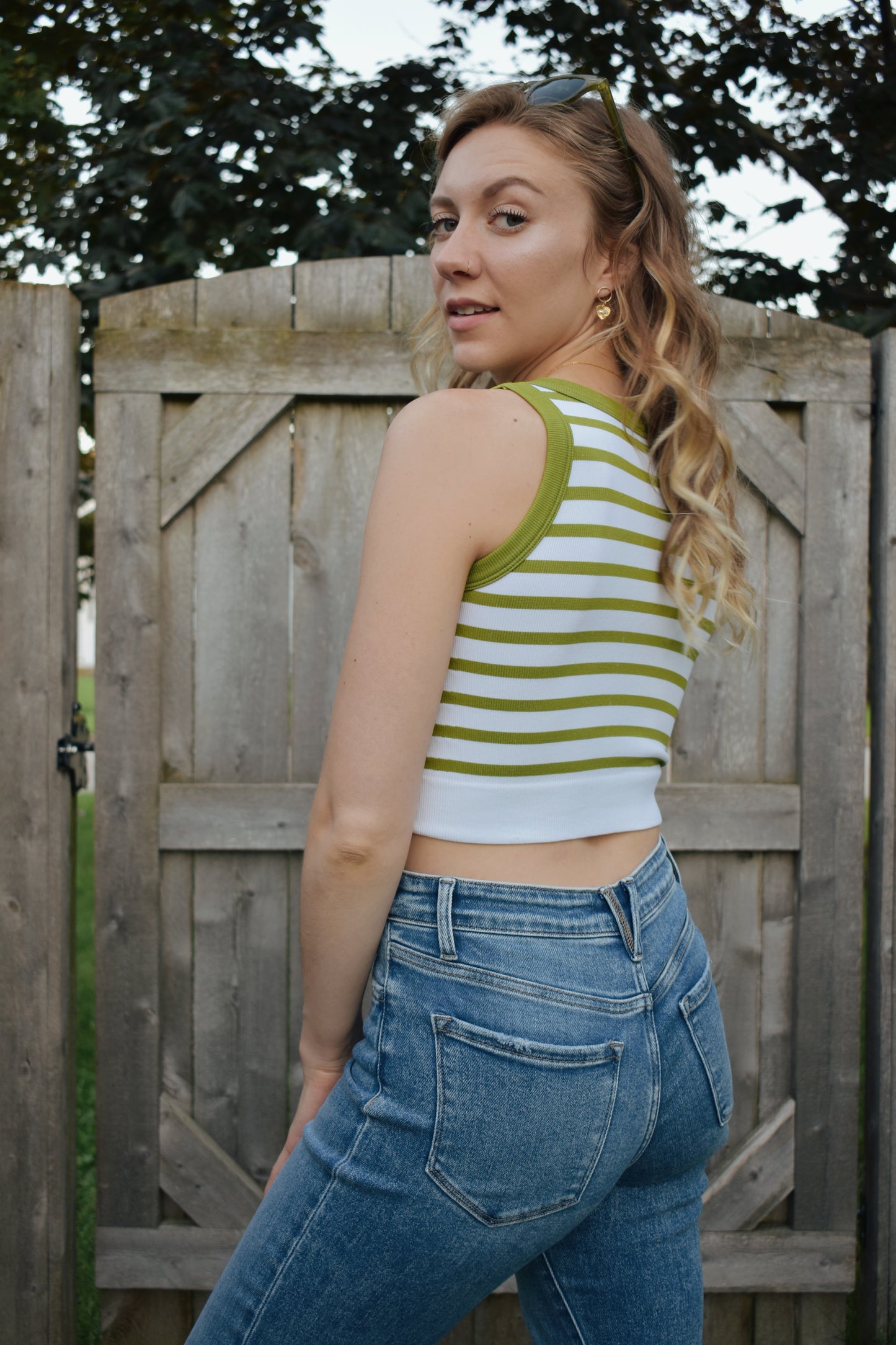 cropped tank with horizontal stripes. thick band of white around bottom hem. arm and neck line hem are solid color. crew neck. stretchy. 