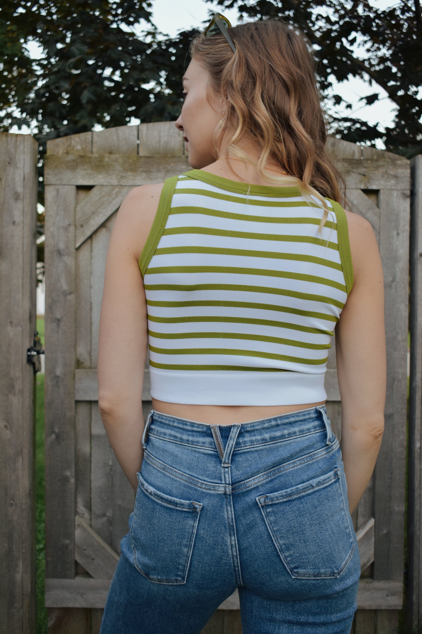 cropped tank with horizontal stripes. thick band of white around bottom hem. arm and neck line hem are solid color. crew neck. stretchy. 