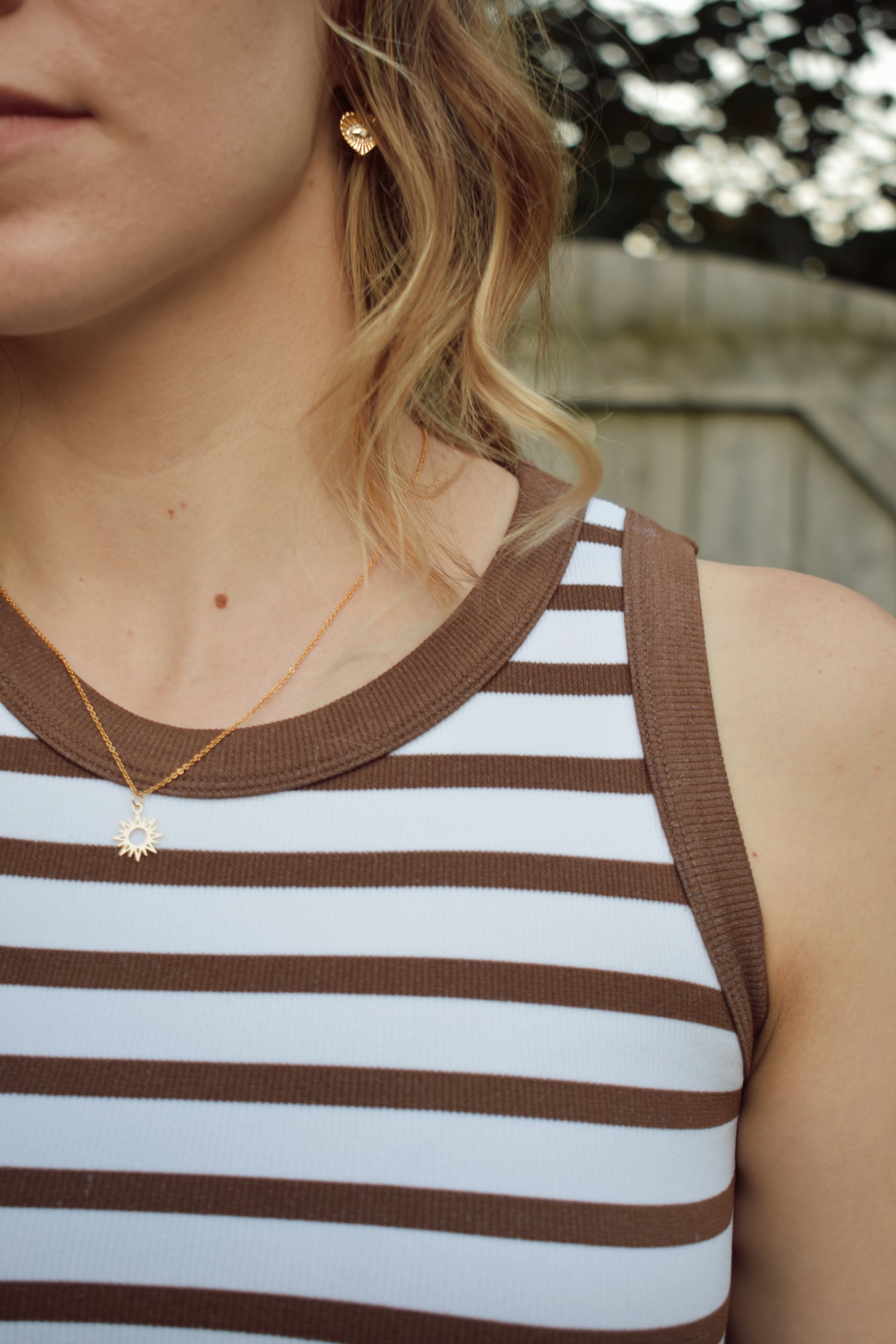 cropped tank with horizontal stripes. thick band of white around bottom hem. arm and neck line hem are solid color. crew neck. stretchy. 