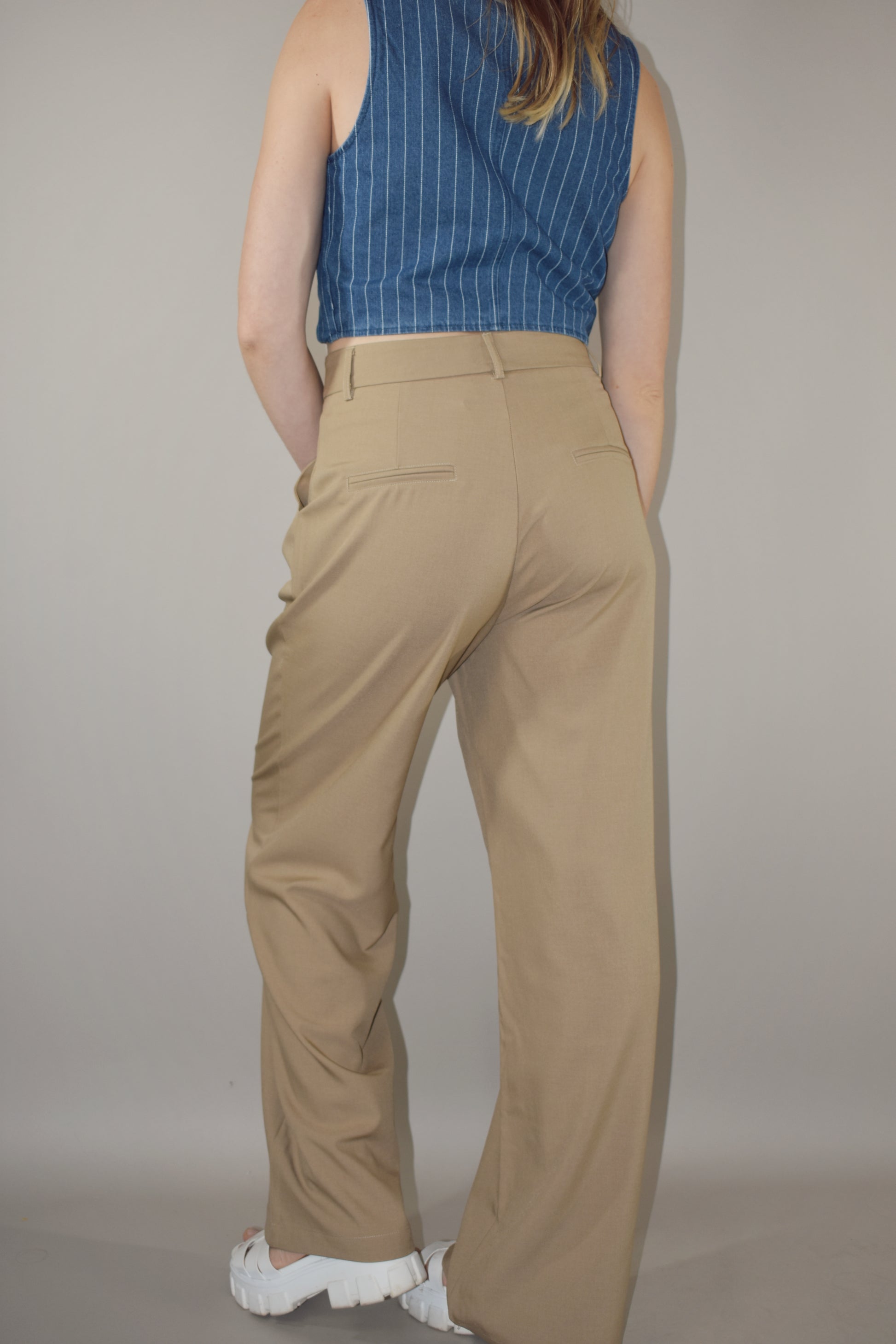 straight leg trousers with a slight baggy look. pleated with pockets and full length. length runs a little long. back doesn't have real pockets. pants have beltloops and a zip and button enclosure.