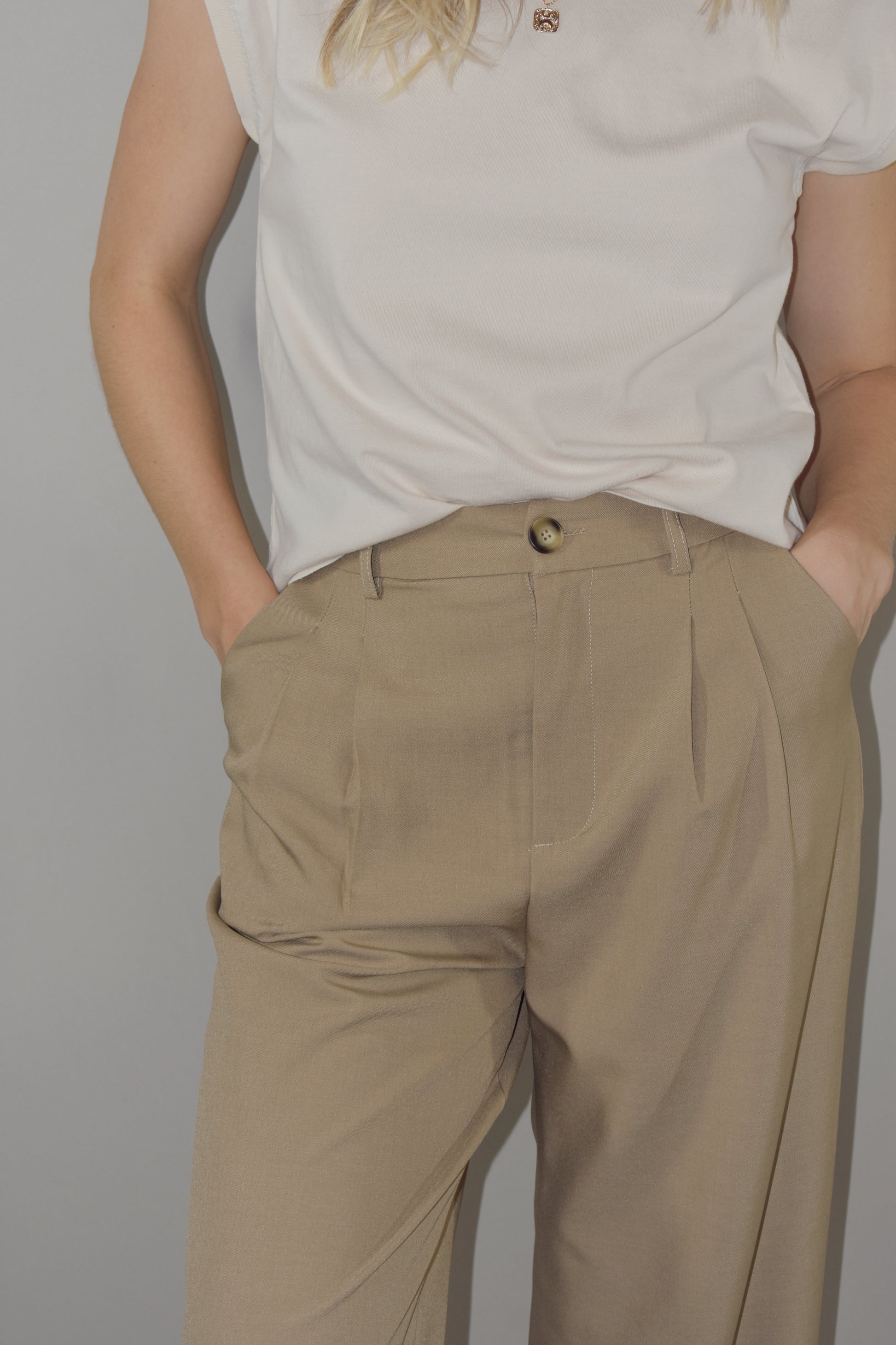 straight leg trousers with a slight baggy look. pleated with pockets and full length. length runs a little long. back doesn't have real pockets. pants have beltloops and a zip and button enclosure.